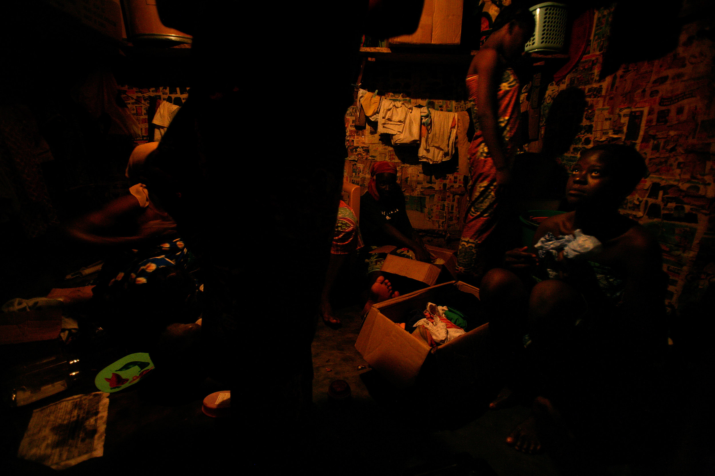  Kayayo girls in their early teens prepare to sleep after the workday in Old Fadama slum in Accra, Ghana on Feb. 9, 2009. 14 girls from the same village sleep on the floor of this wooden shack. 