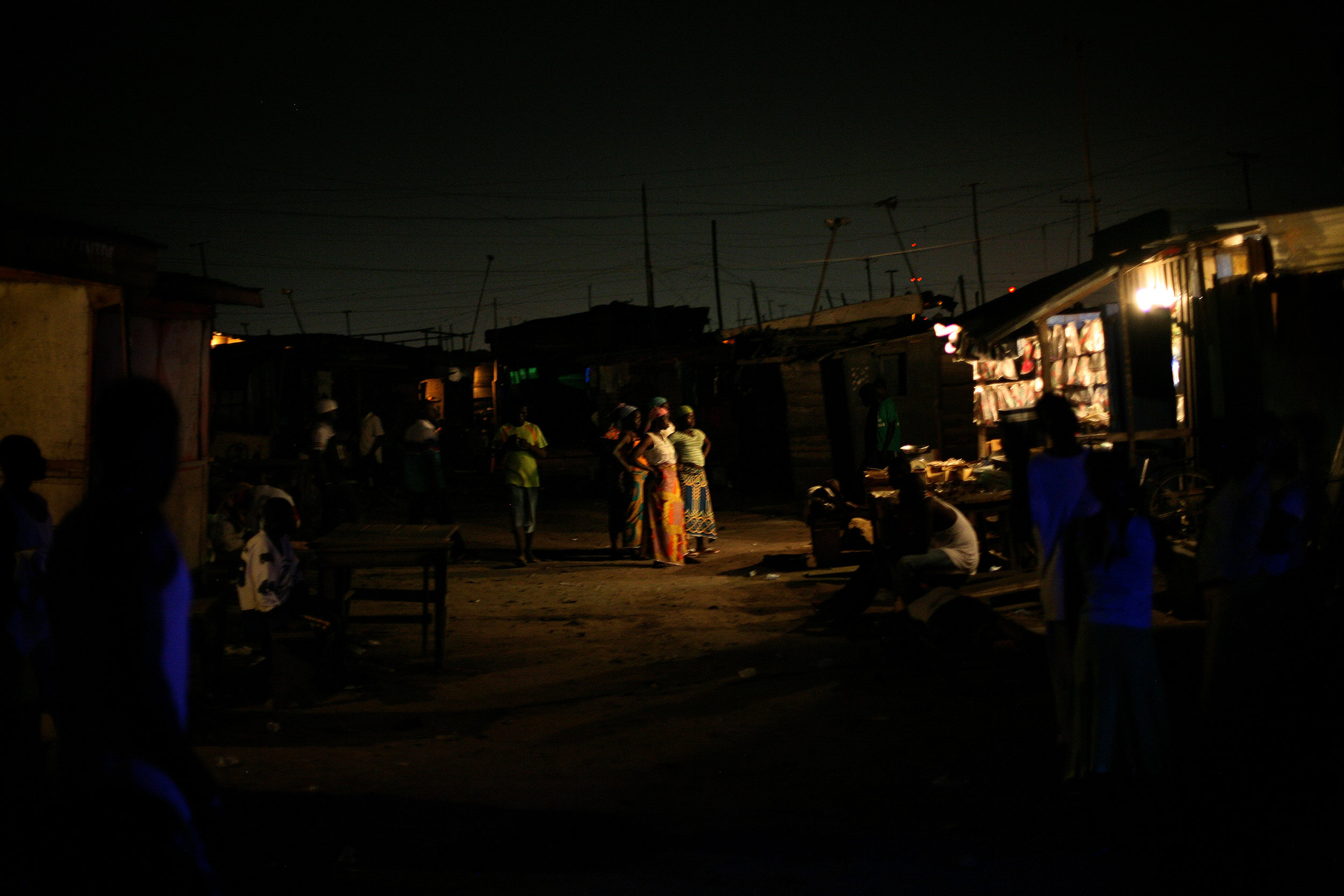  Kayayo girls watch a film playing in the midst of Old Fadama slum, where they live in Accra,  Ghana on March 14, 2009. 