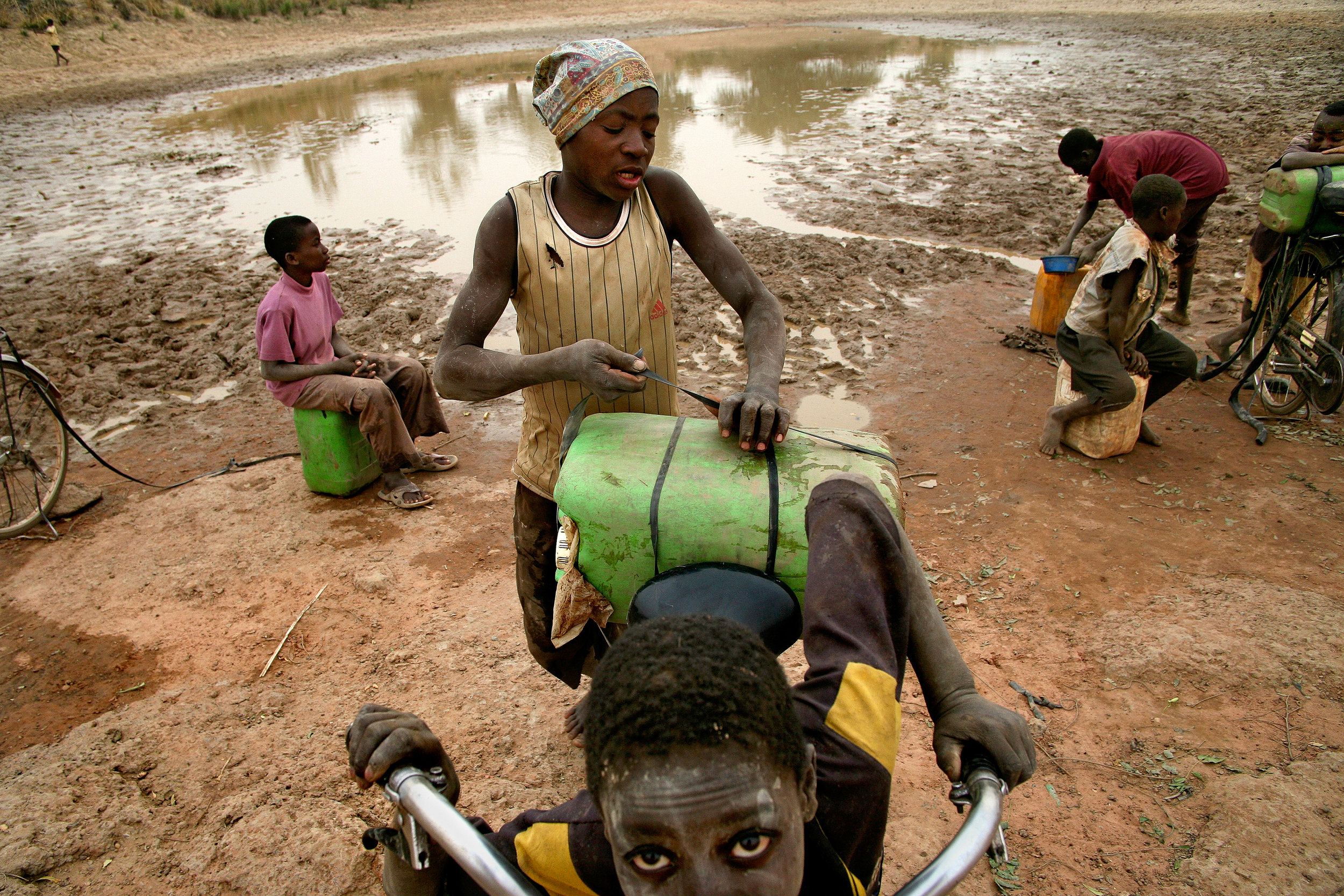  Children collect drinking water from a reservoir in Wantugu, Northern Region, Ghana on Jan. 4, 2007. The dam dries up for several months during northern Ghana's dry season, and the people of Wantugu have to walk several miles to the next village to 