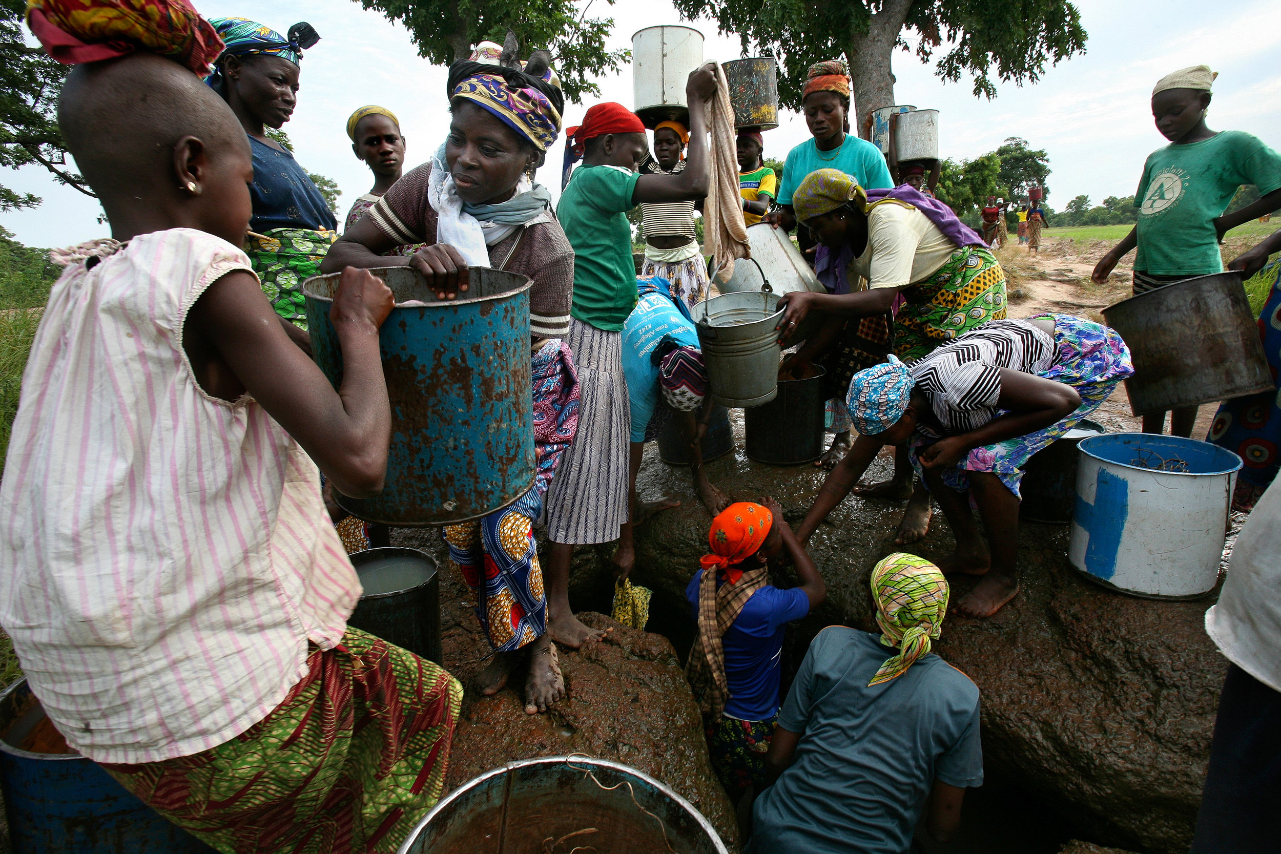  Women gather water from a hand-dug well in Wantugu, Ghana on July 15, 2007. During Ghana's rainy season, wells such as this one collect water that is accessible and free of Guinea worm. 