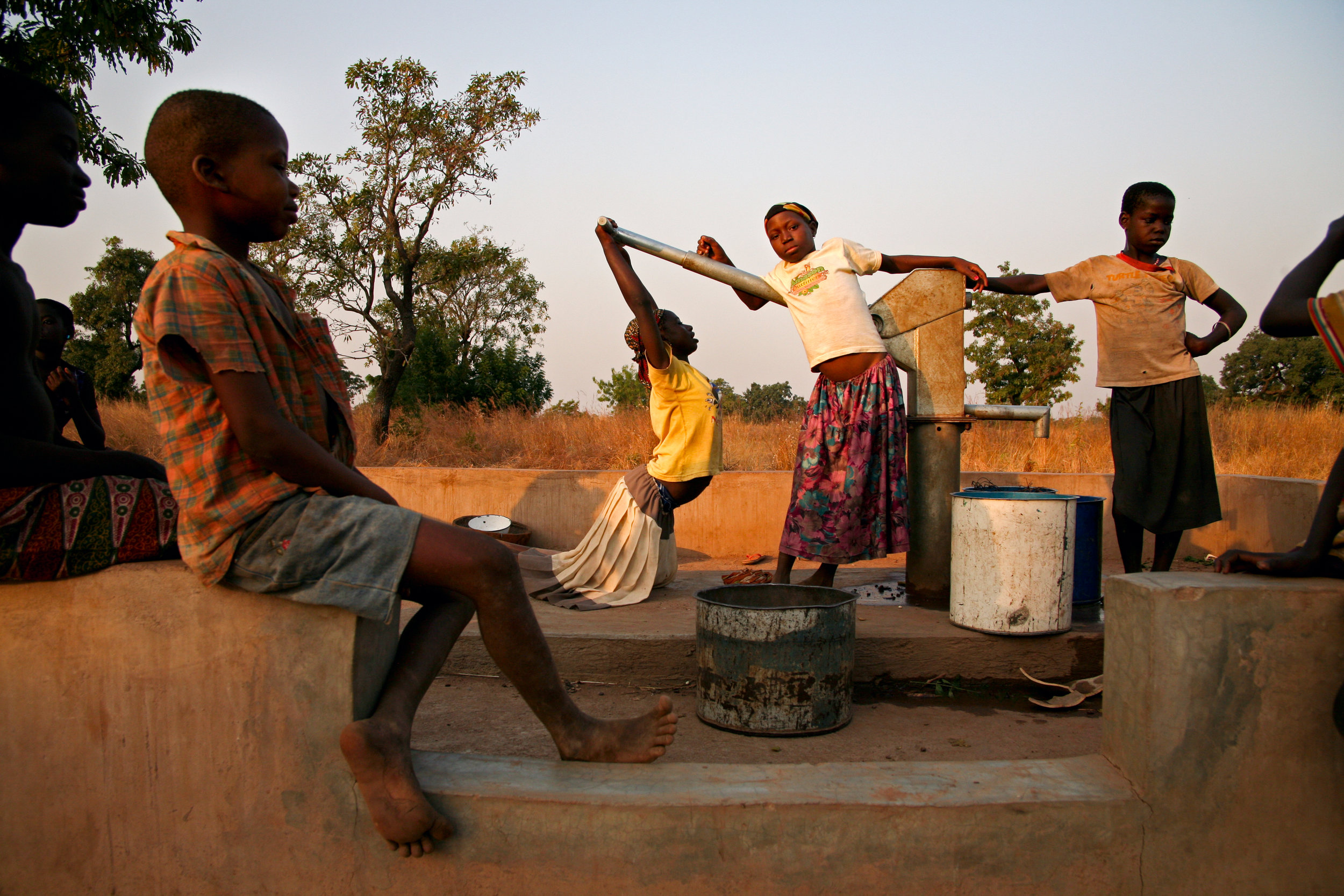  Children wait for water at a drilled borehole well in Wantugu, Ghana on Dec. 21, 2006. Several such wells have been installed as an attempt to solve the village's severe water shortage, but the water table in the ground is too low, and sometimes it 