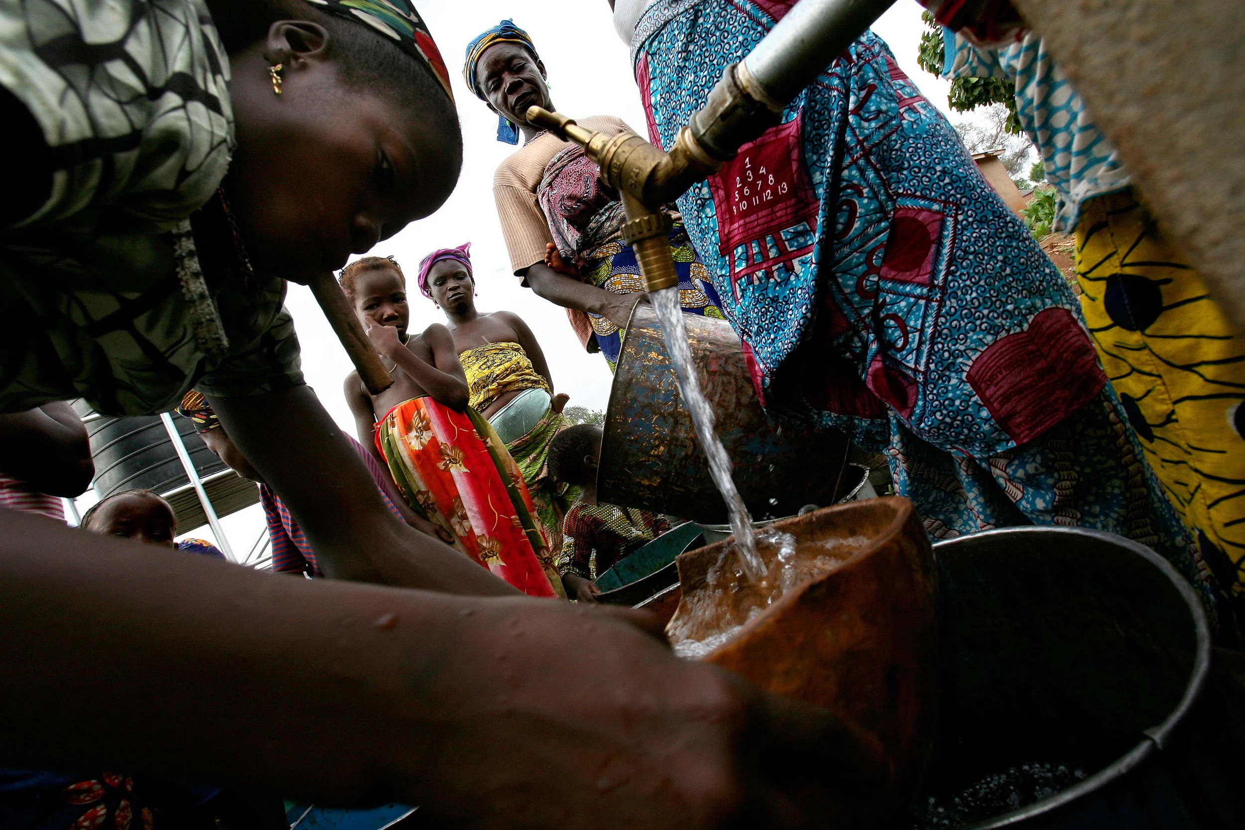 Over a year after the project was initiated, women gather around a distribution point at the recently completed water system in Wantugu, Ghana on Nov. 16, 2007. Some health workers fear that, despite the health benefits, villagers will not use the water system because they have to pay a small fee every time they fetch water.