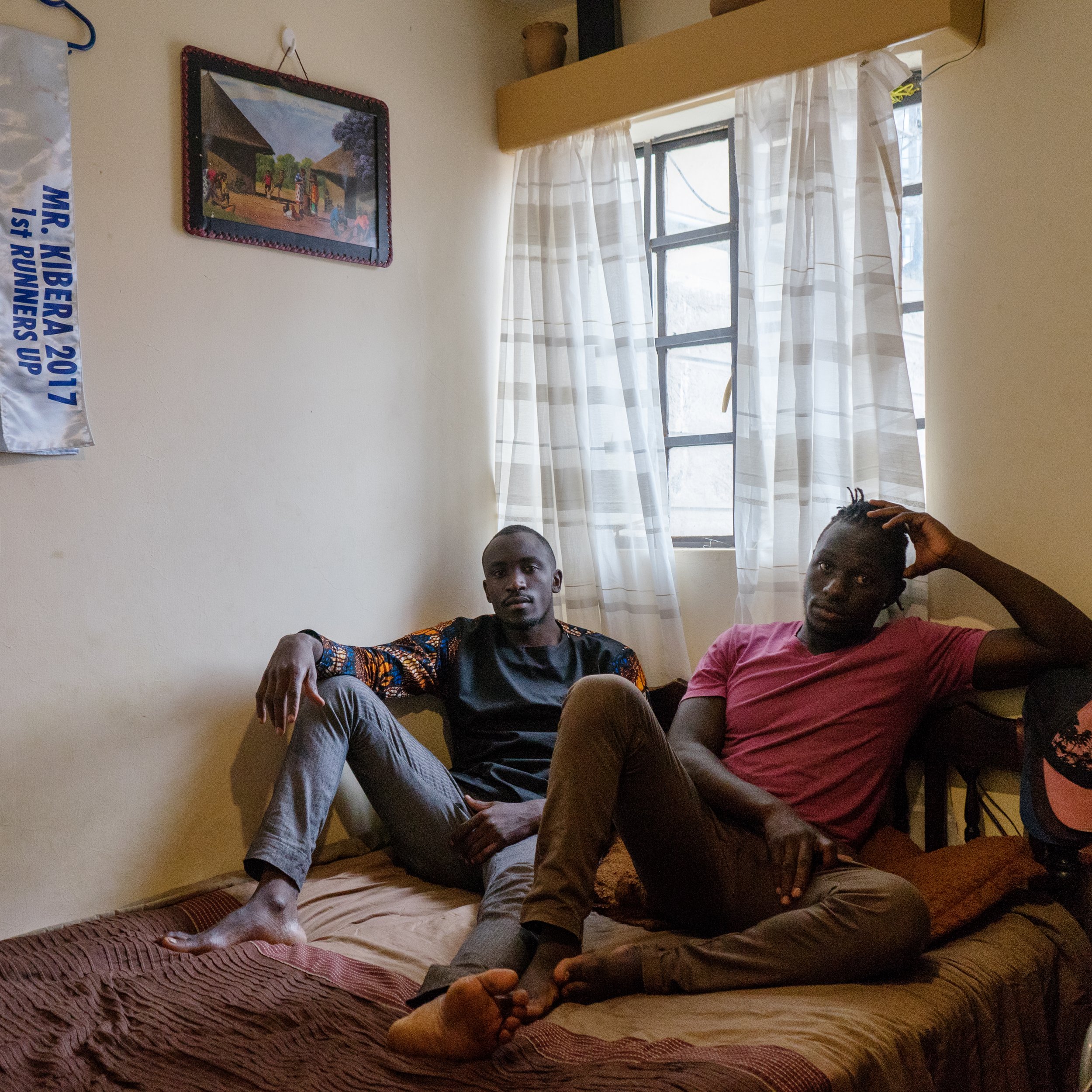  Collince Onyango, 27, left, and his brother, Raphael Oduor, 24, both university students, in the home they rent from a resident who received housing built under the Kenya Slum Upgrading Program. Kibera, Nairobi, Nairobi County, Kenya. Photographed M