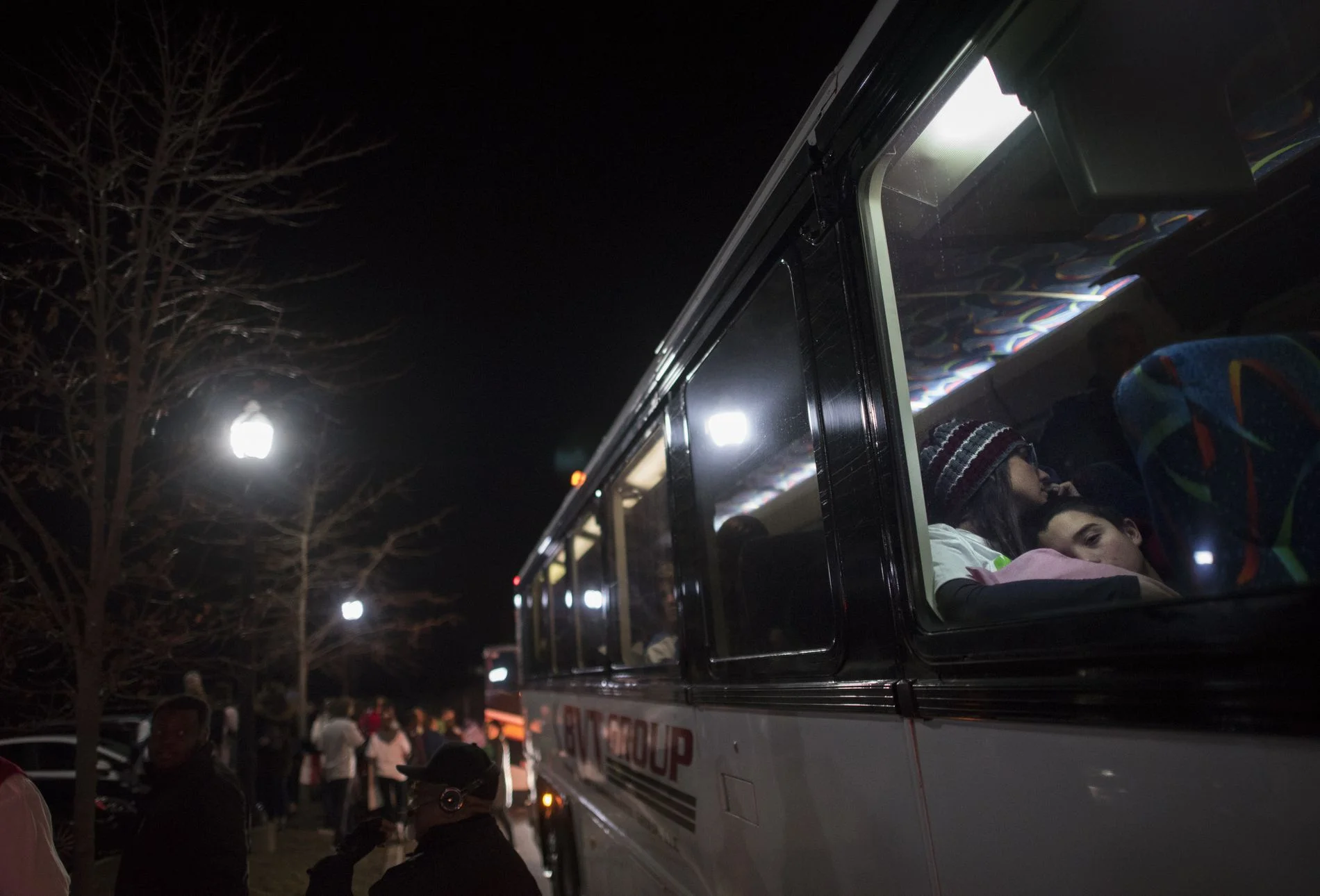 A small group stands in a parking lot, waiting for buses to arrive around 5 am at Fairfield Hills in Newtown, Conn., on March 24, 2018. FRED LUM/THE GLOBE AND MAIL