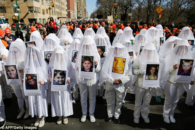 People display portraits of Sandy Hook elementary school shooting victims as they take part in the March for Our Lives in New York on March 24 
