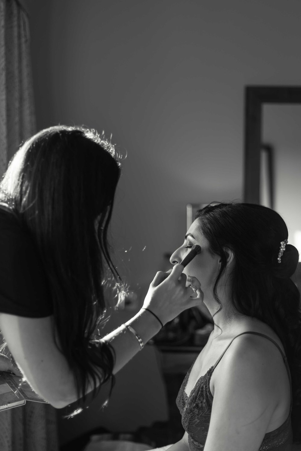 Black and white photograph of bride having make up applied at Celtic Manor Resort