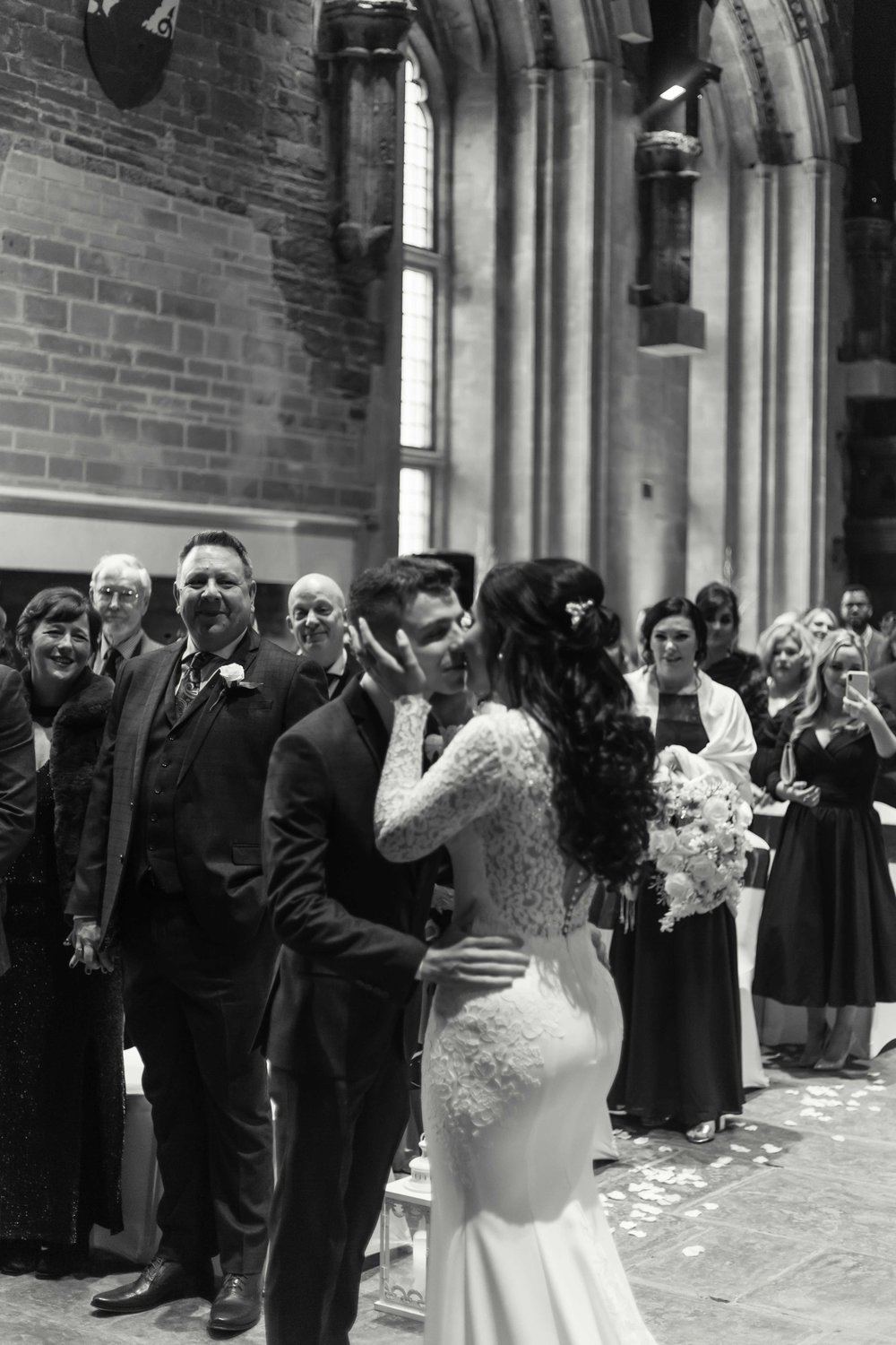 Black and white image of bride and groom enjoying their first kiss