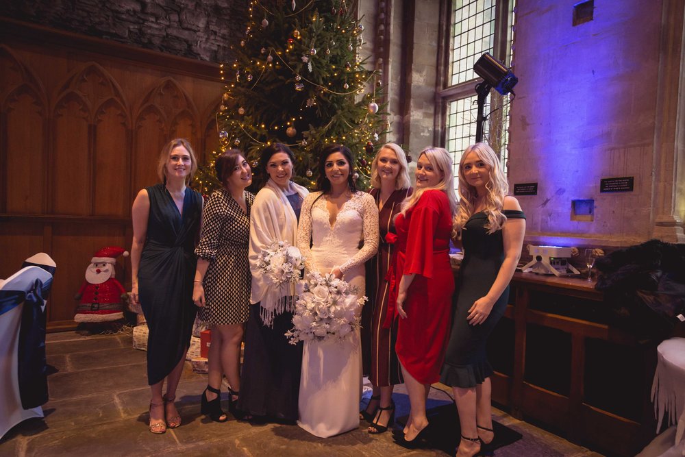 Image of bride with friends next to a large christmas tree at Caerphilly Castle