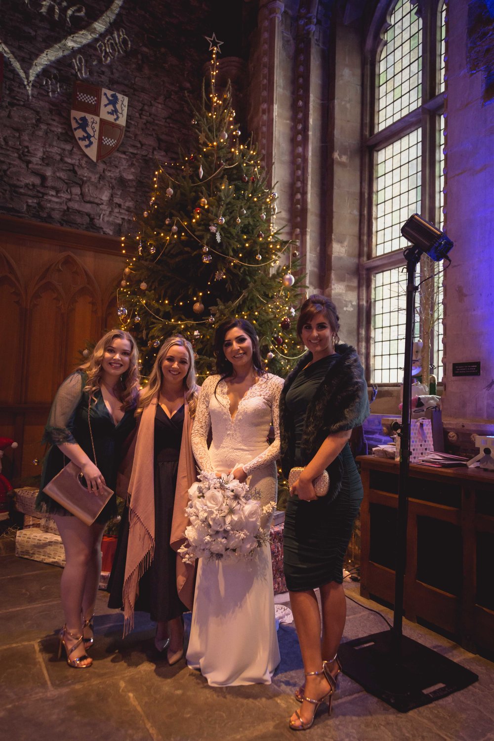 Image of bride with friends next to a large christmas tree at a South Wales Wedding