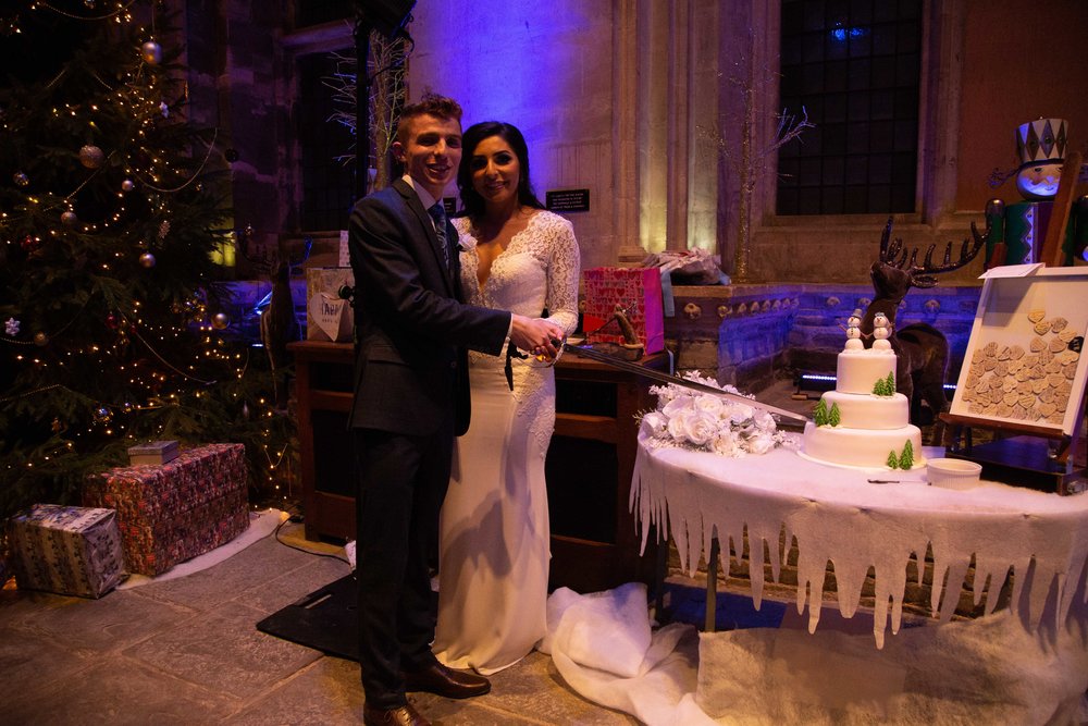 Bride and groom cutting the cake with a sword at Caerphilly Castle