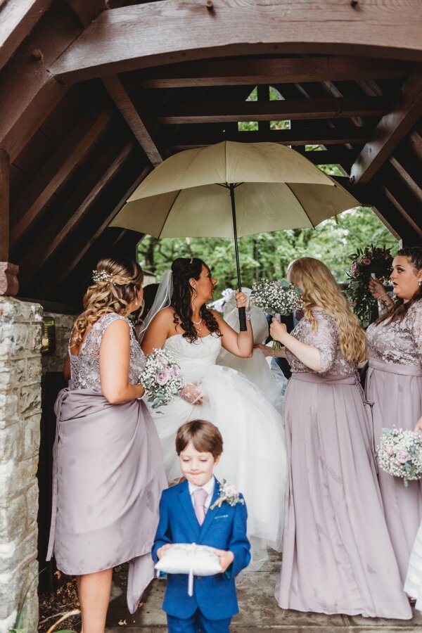 Bride holding an umbrella in the rain at a Cardiff Wedding
