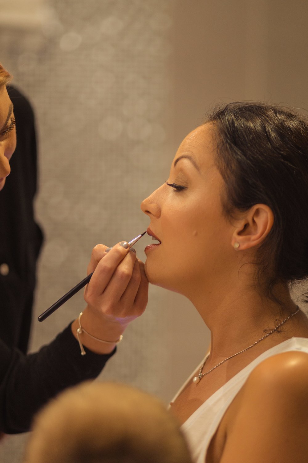 Photograph of bride having her make up applied