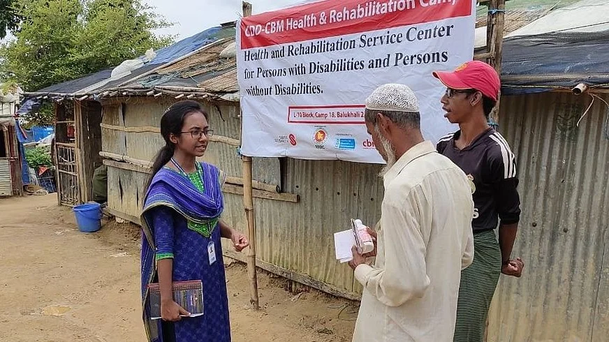Tahmida Akter discusses feedback and complaint mechanisms with persons with disabilities from the Rohingya population in the Cox's Bazaar refugee camp. July 2019. ©CBM
