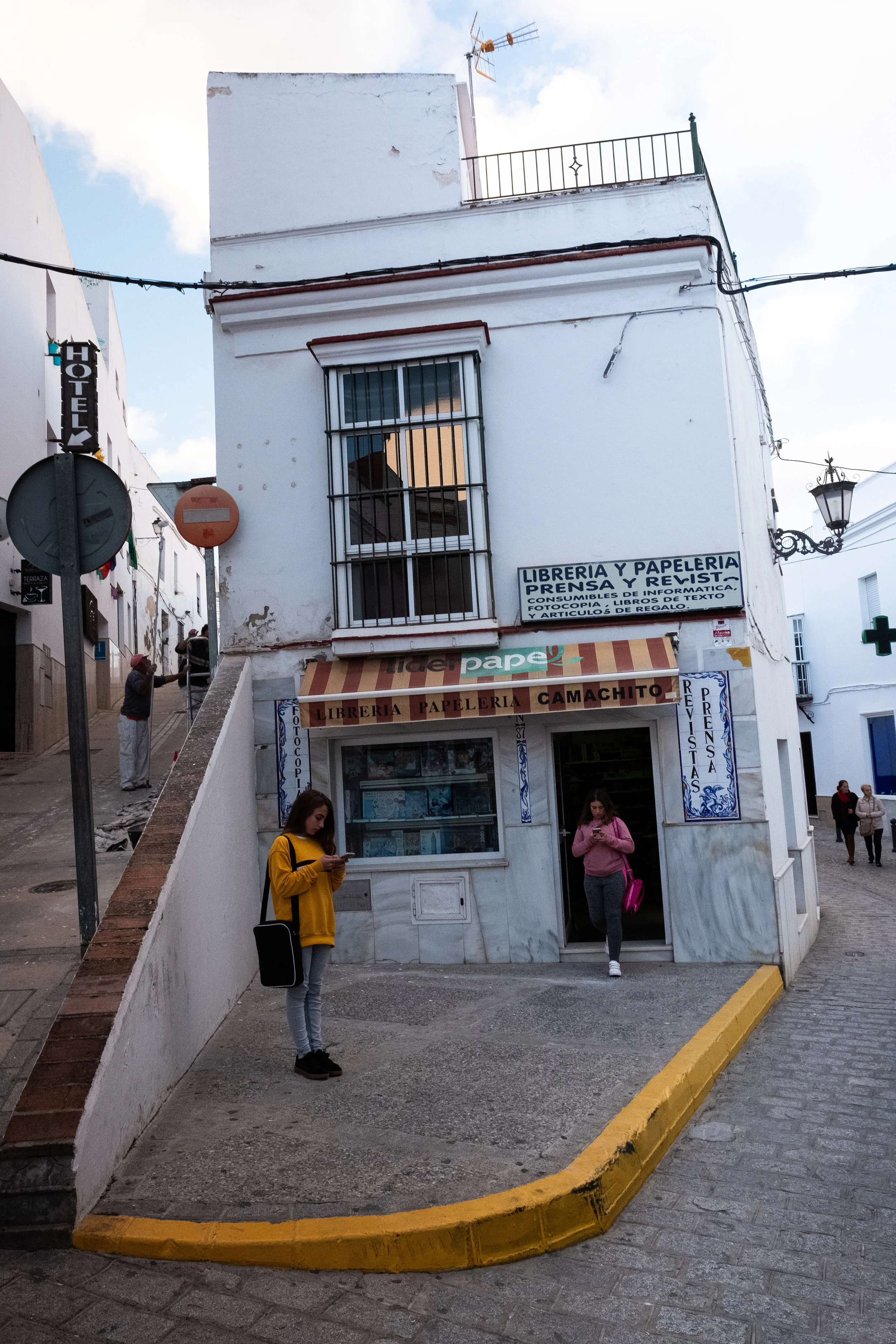 Girl matching her sweatshirt to curb in Arcos de la Fronterra, Andalucia.