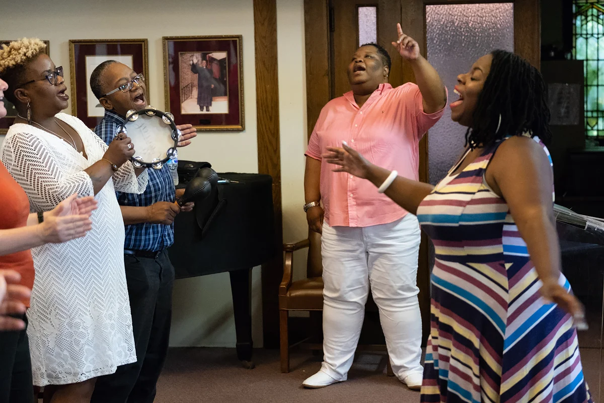 Rev. Shanea Leonard, the pastor of Judah Fellowship Christian Church, sings along with the congregation during worship. Anita Levels directs the worshipers in song.