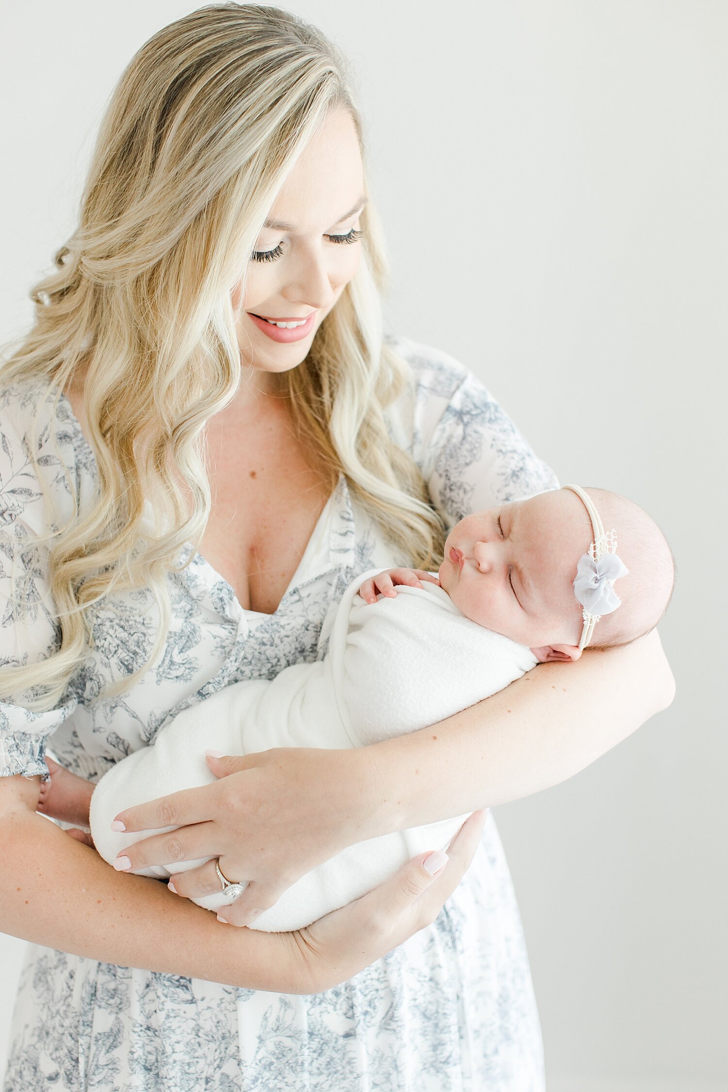 Mom holding her baby girl during newborn session in studio in Fairfield County, CT. Photos by Kristin Wood Photography.