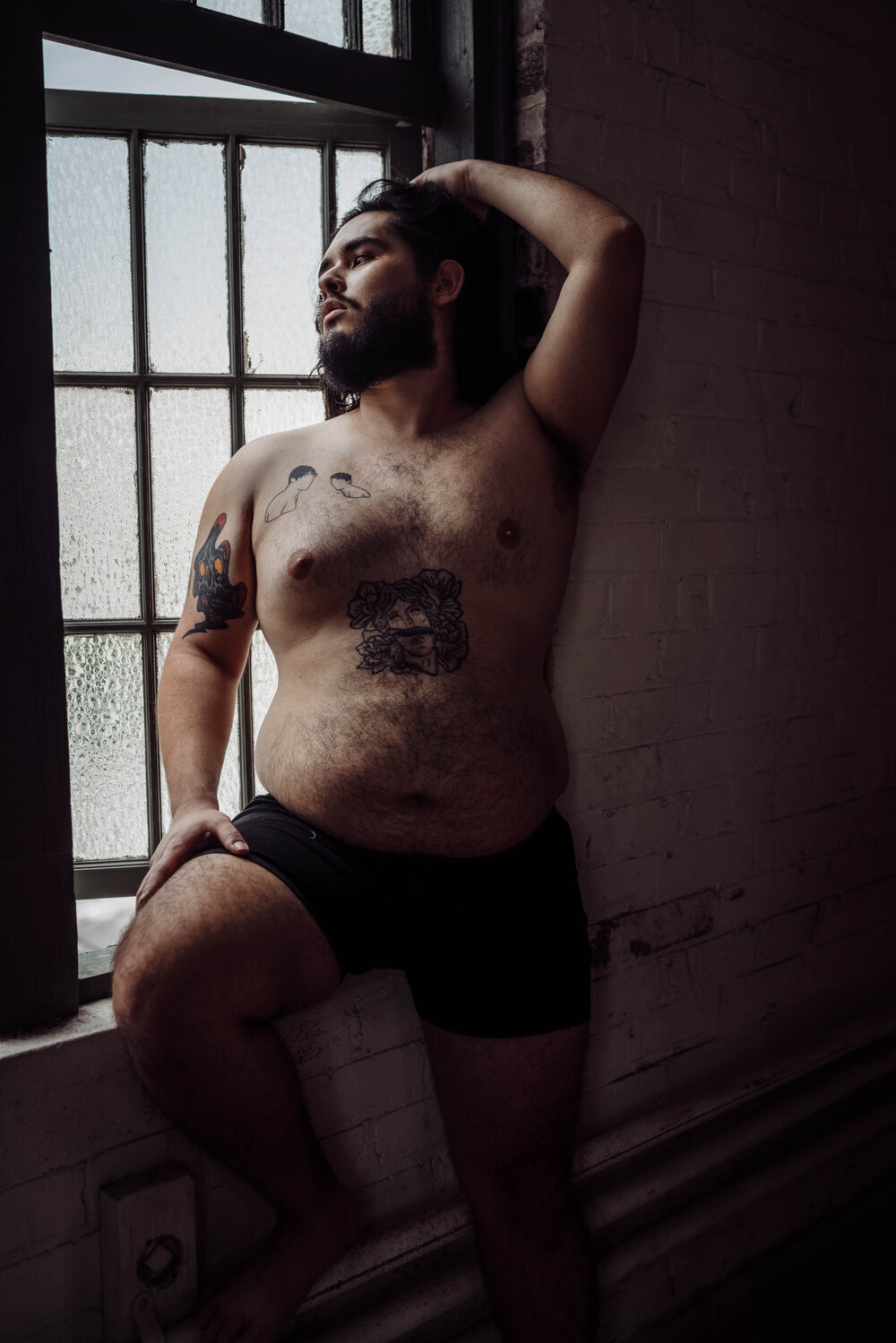 Oklahoma City Male Boudoir bearded shirtless man with tattoos looking out window