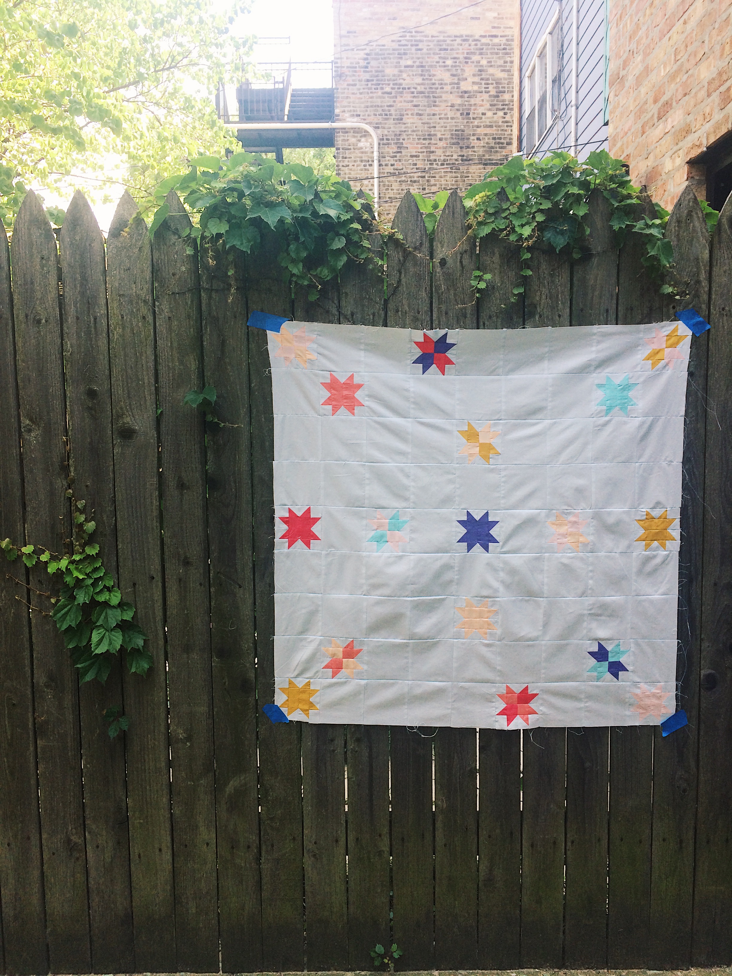Finished "Tiny Stars" quilt top hung in my old backyard in Chicago.
