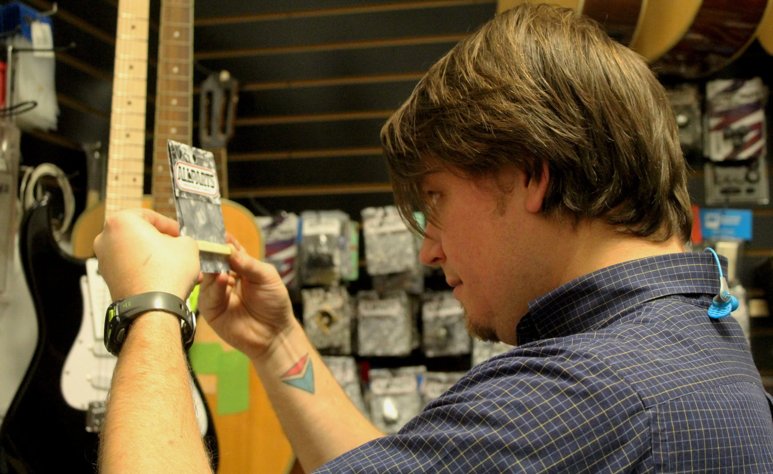 Brent Moore compares two guitar shoulders, Friday, Jan. 19, 2018, at CoMo Guitar Works in Columbia, Mo. “It’s fun,” Moore said. “Yeah, it’s just fun. The ultimate thing is that I just really enjoy it.”