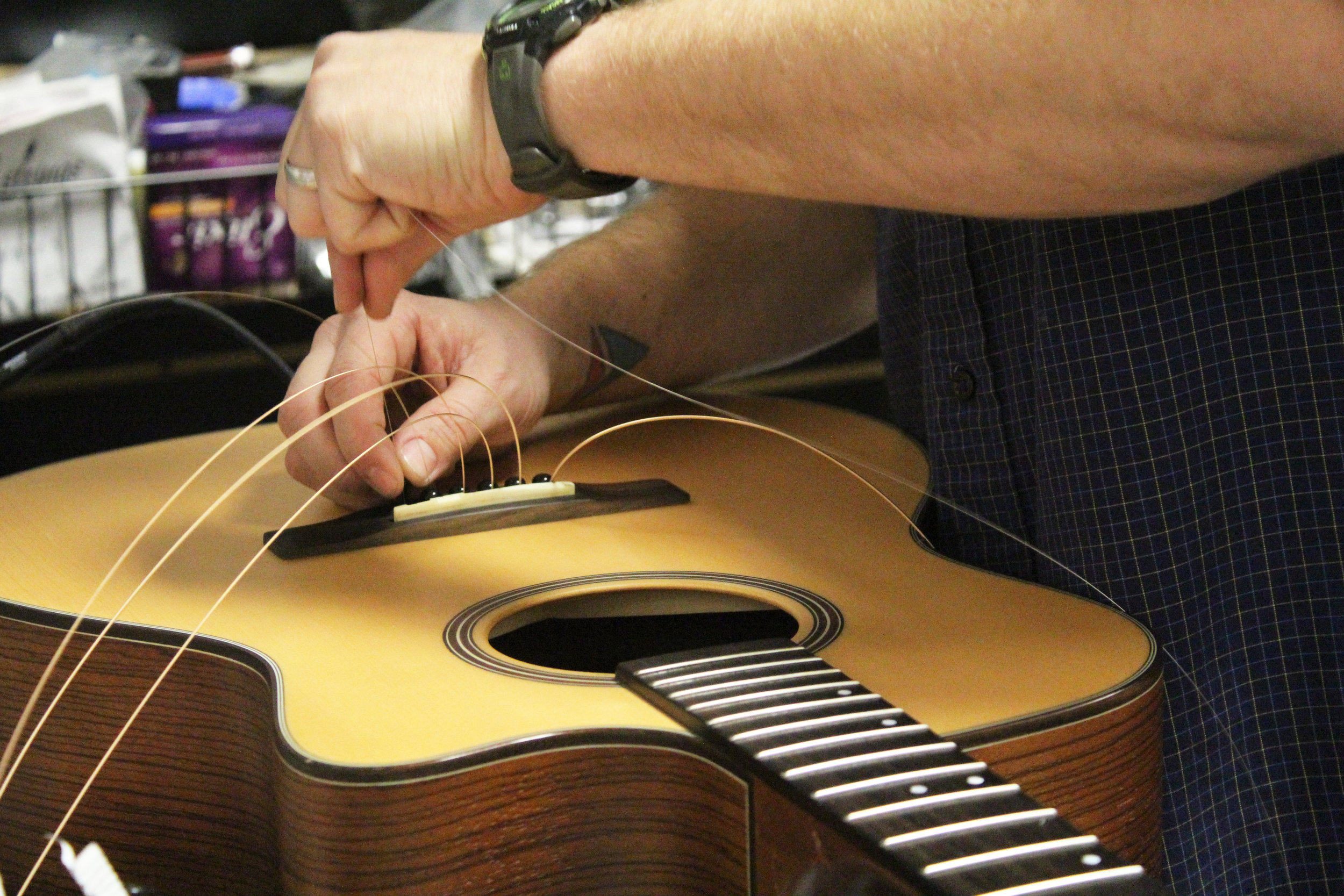 Brent Moore replaces guitar strings on Friday, Jan. 19, 2018, at CoMo Guitar Works in Columbia, Mo. Moore put in a taller bridge on the guitar so the strings will have more room.