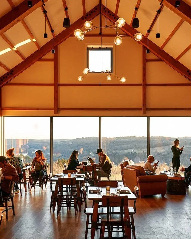 In the tasting room at Seminary Hill Cidery, timber, glass, and light converge to frame the Delaware River Valley. Designed by River Architects to Phius standards, this modern bank barn celebrates both heritage and innovation &mdash; where sustainabi