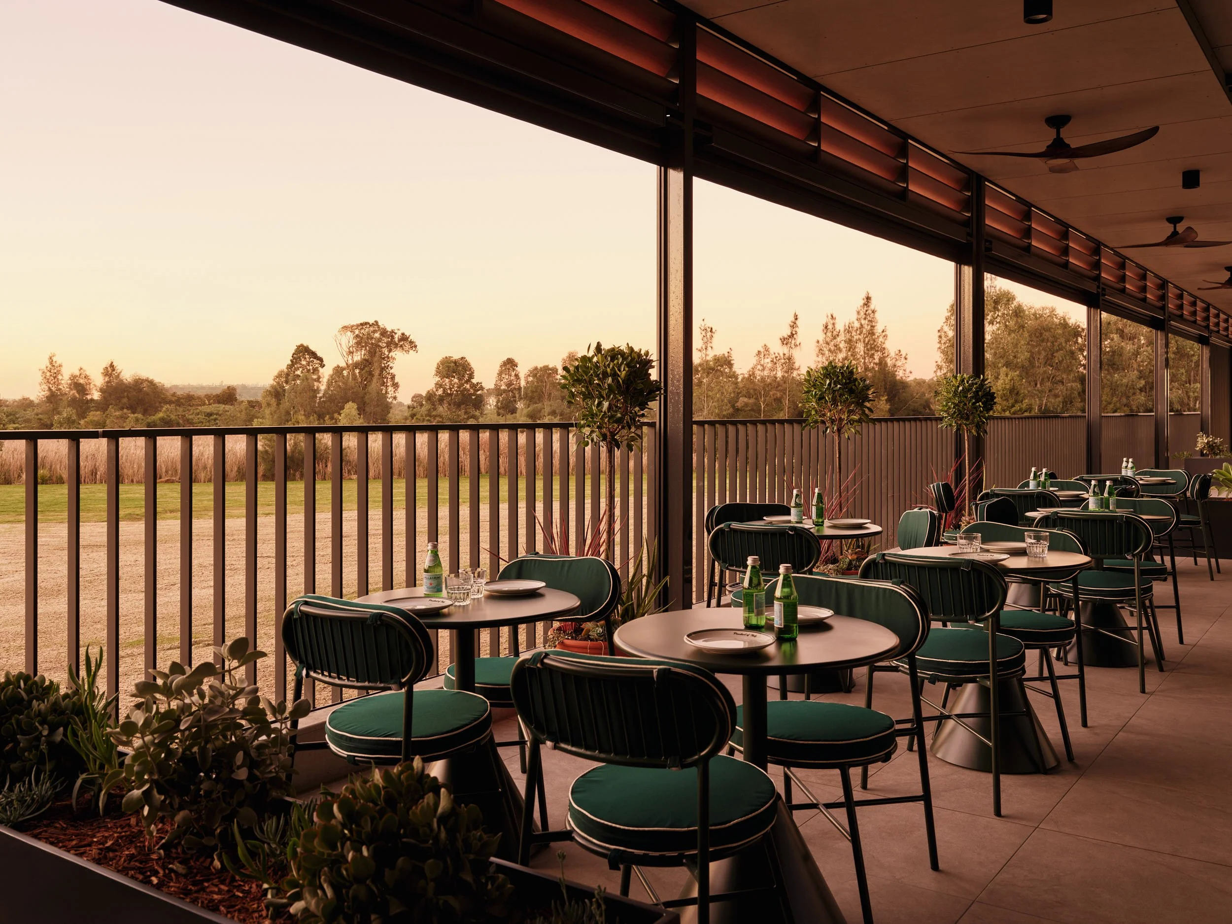 Outdoor restaurant with dark green velvet chairs with custom furniture by interior designers Al & Co Haus of Design in Sydney