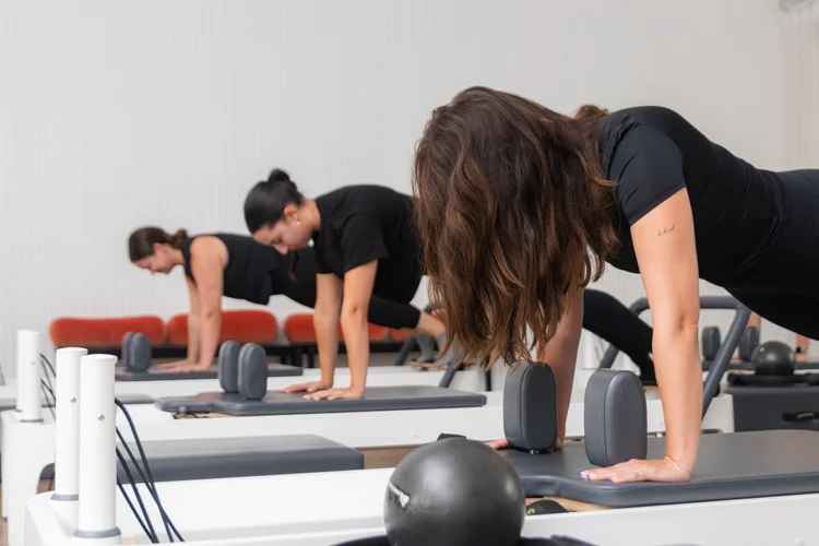 A small group moving together on reformers at Ultra Pilates
