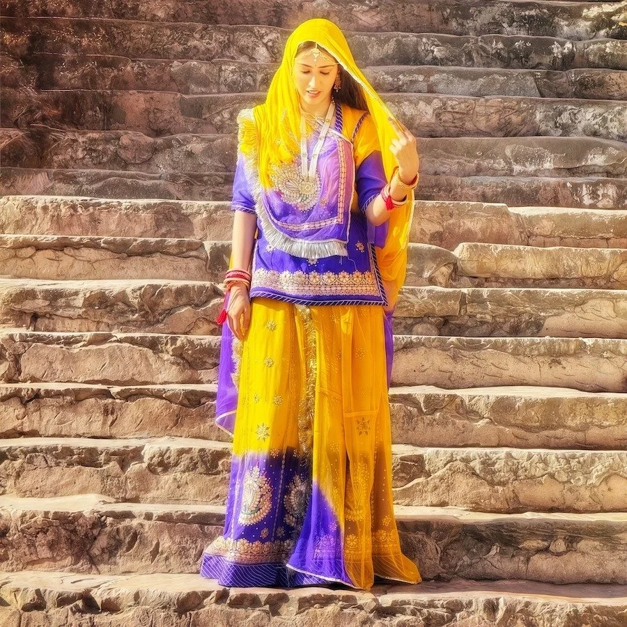 The Lady of Amber Fort
&quot;Jaipur, India. She captures the attention of the crowd as she descends into the courtyard, a vision draped in gold and royal blue, her steps measured, her expression unreadable. The intricate ghagra-choli she wears, adorn