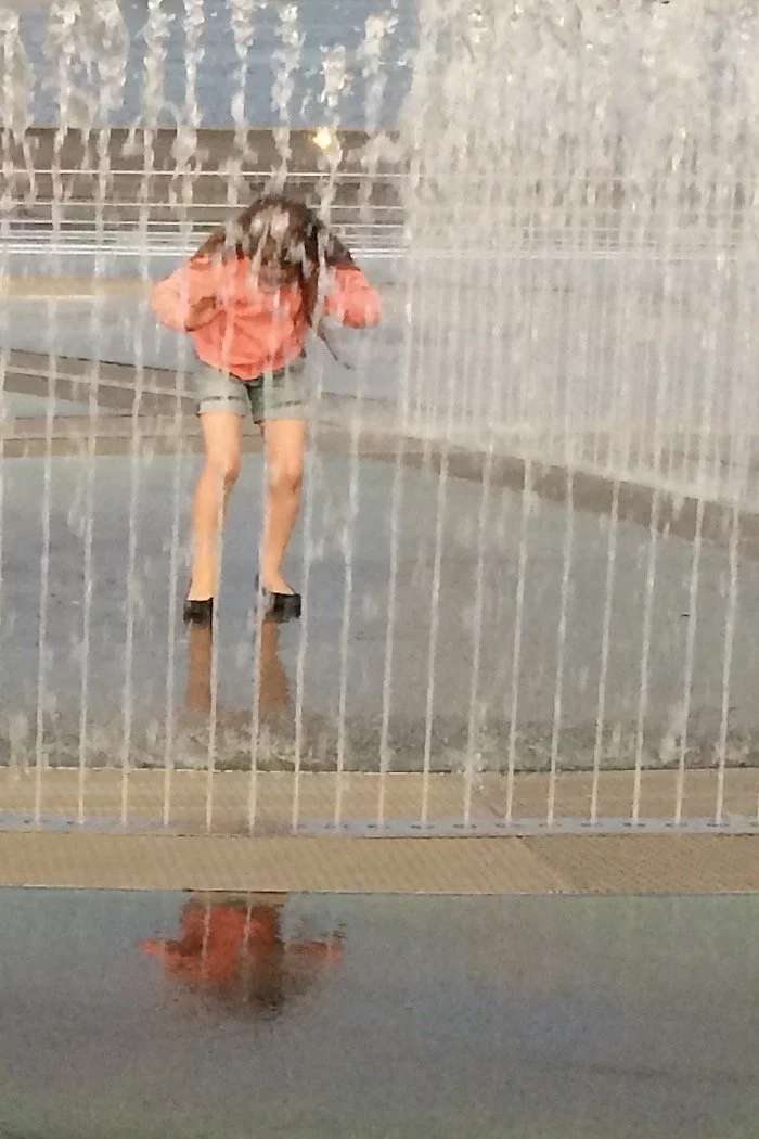 Reflection girl in a fountain Aarhus Denmark