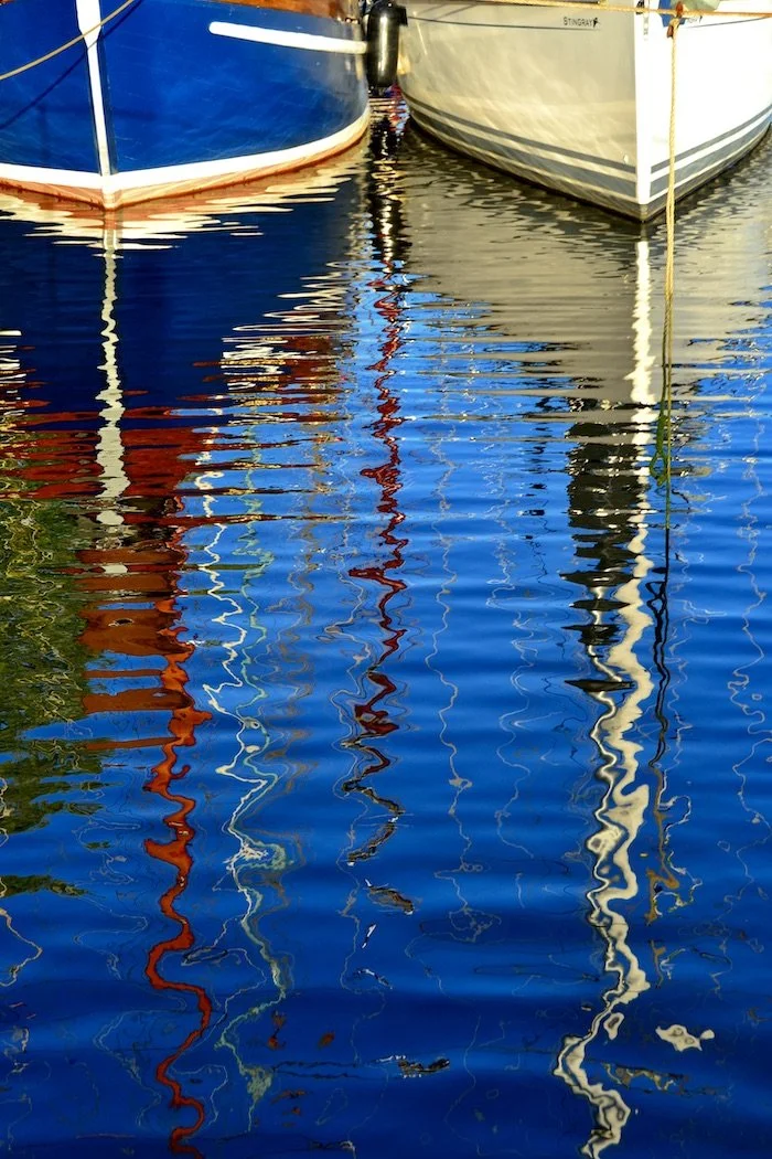 Reflections sailboats in a harbor