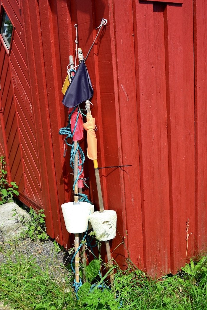 Boats fishing buoys leaning against a red wall Dragør Denmark