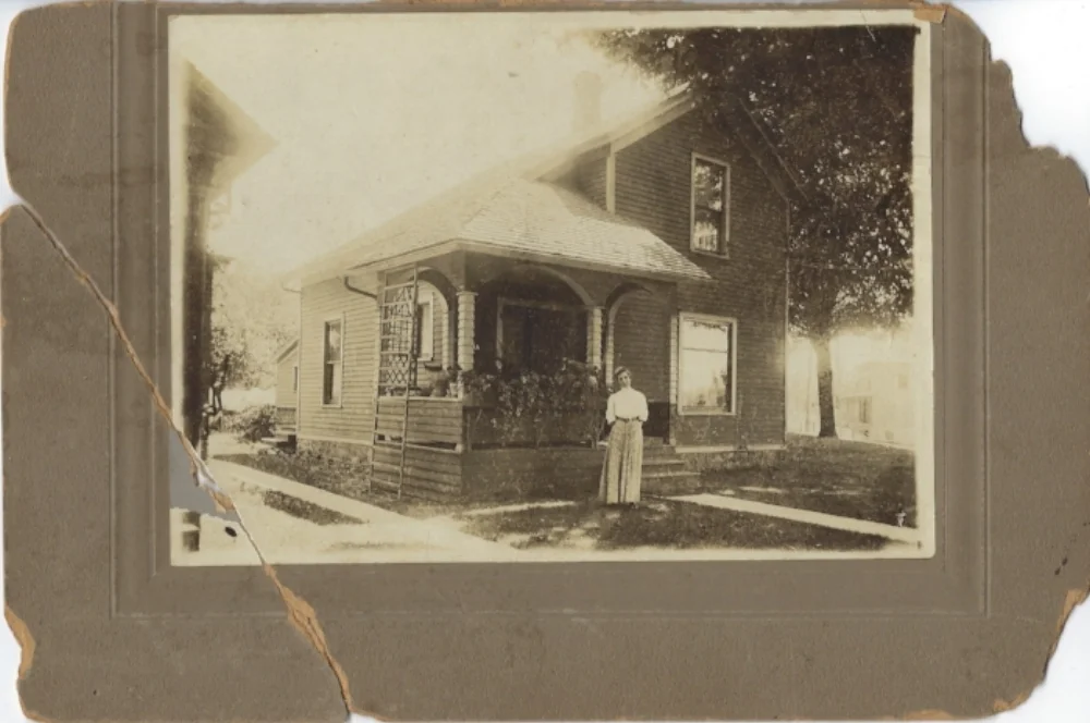 Mary Lochend is standing in front of this home. The house has been demolished and is now part of STAT EMS's parking lot.