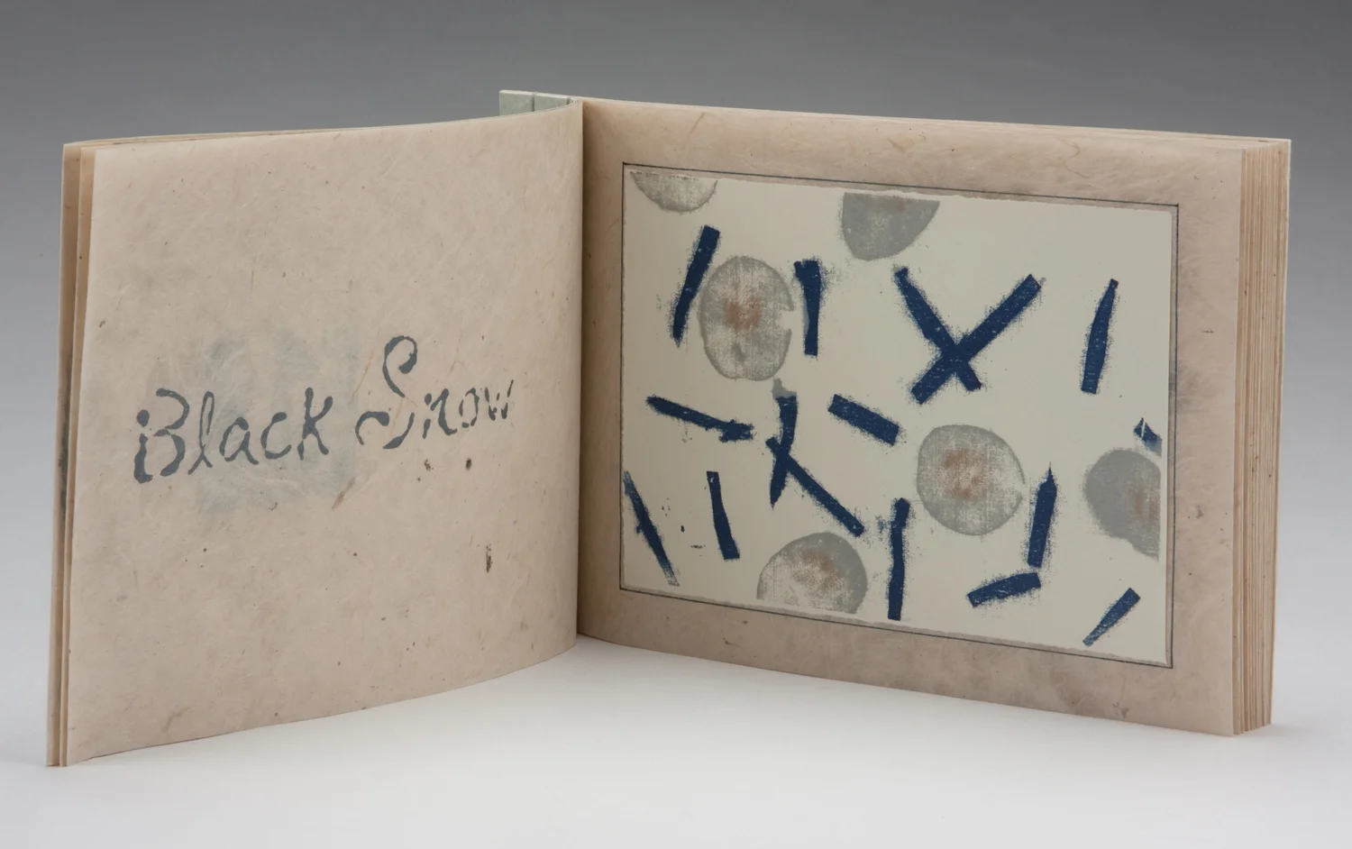 book opened to the print Black Snow, the title printed in the font I created specifically for this book.