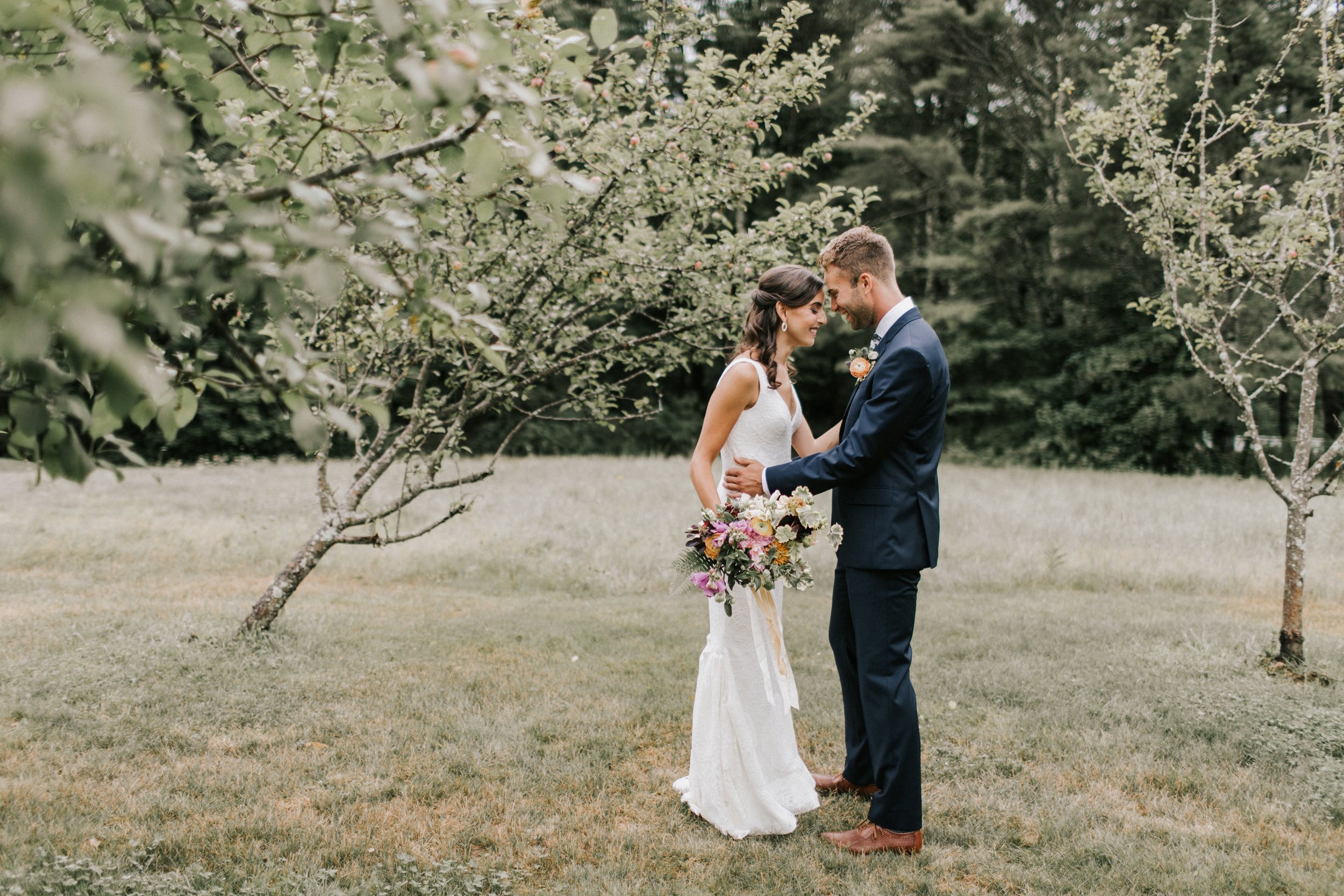 Happy Summer Bride and Groom Embrace in Maine Orchard