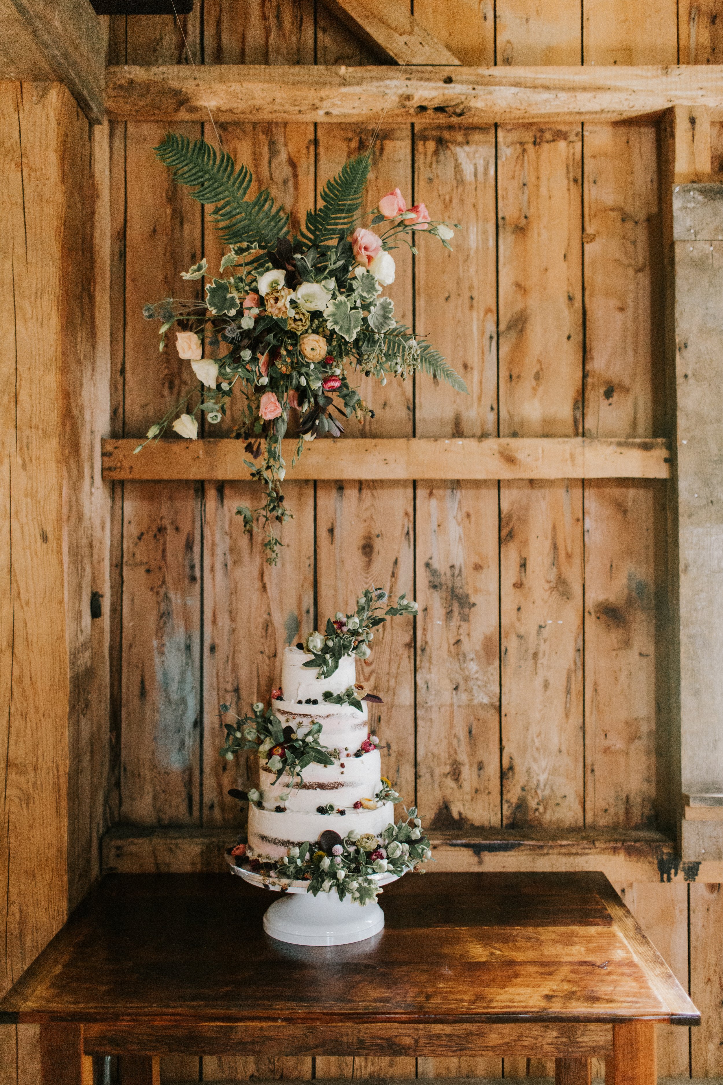 Floating Floral Installation by Cake Display at Maine Barn Wedding