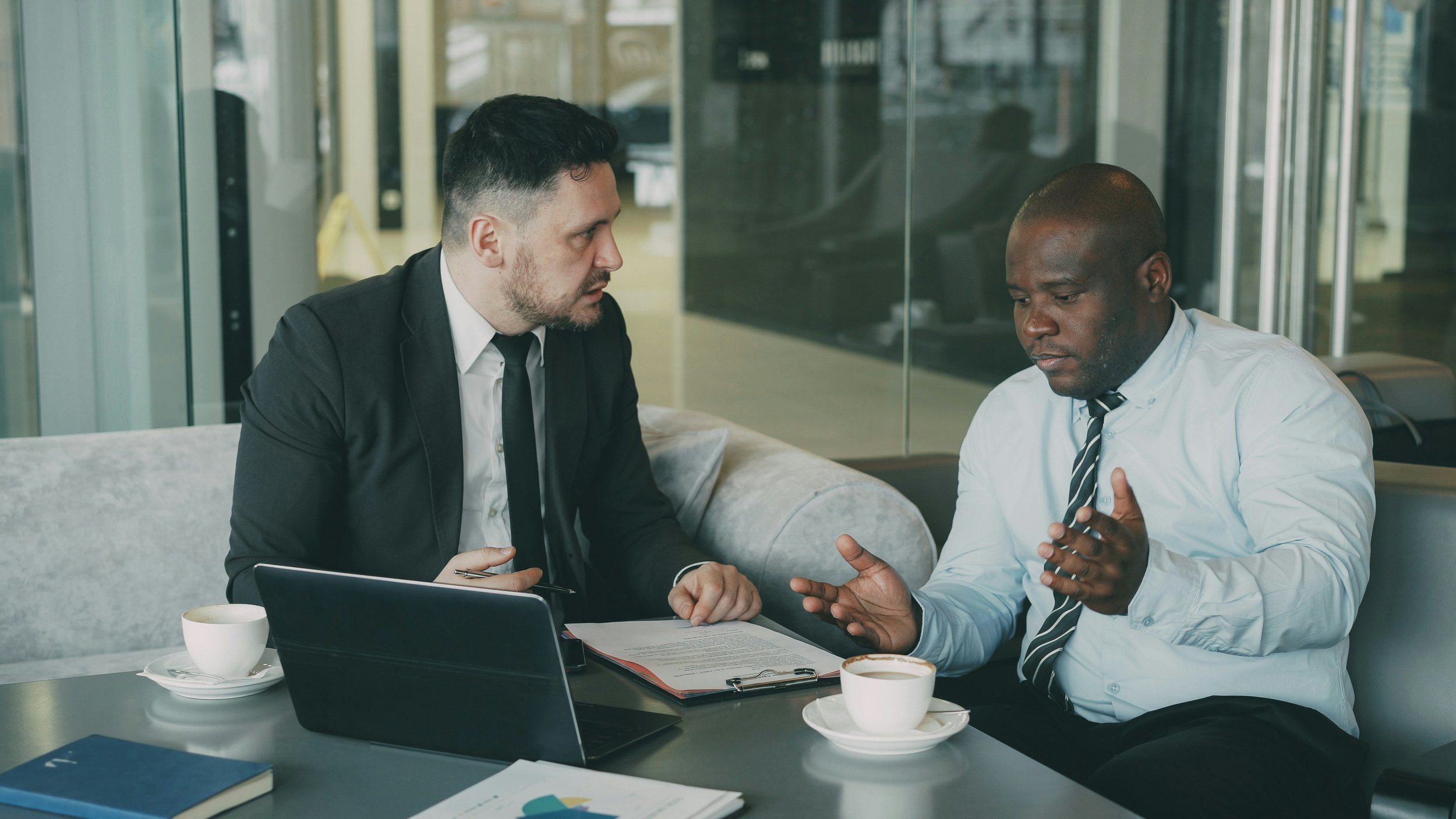 two men sitting in an office arguing
