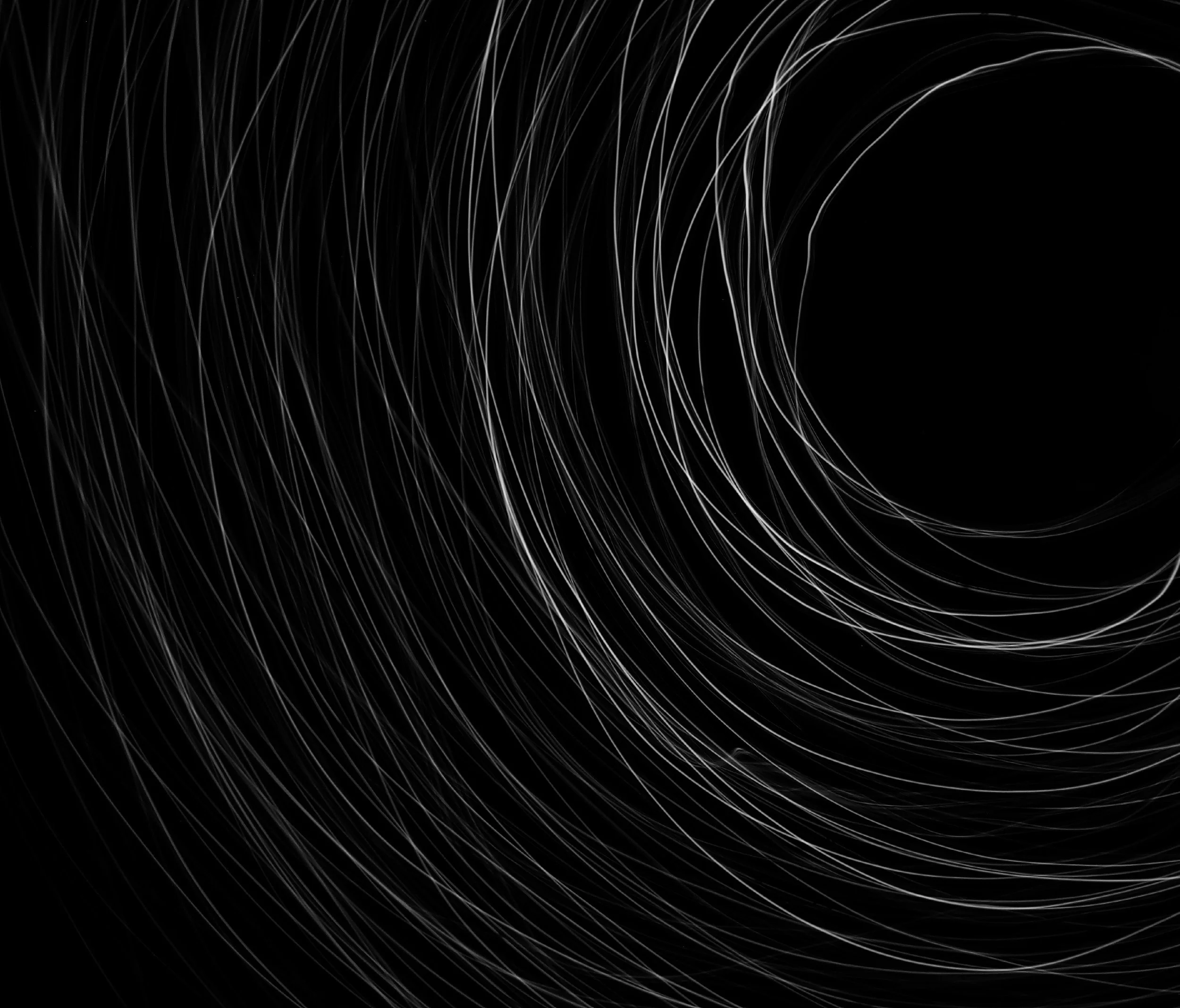 Abstract digital artwork with fine white lines swirling in a spiral pattern against a black background.