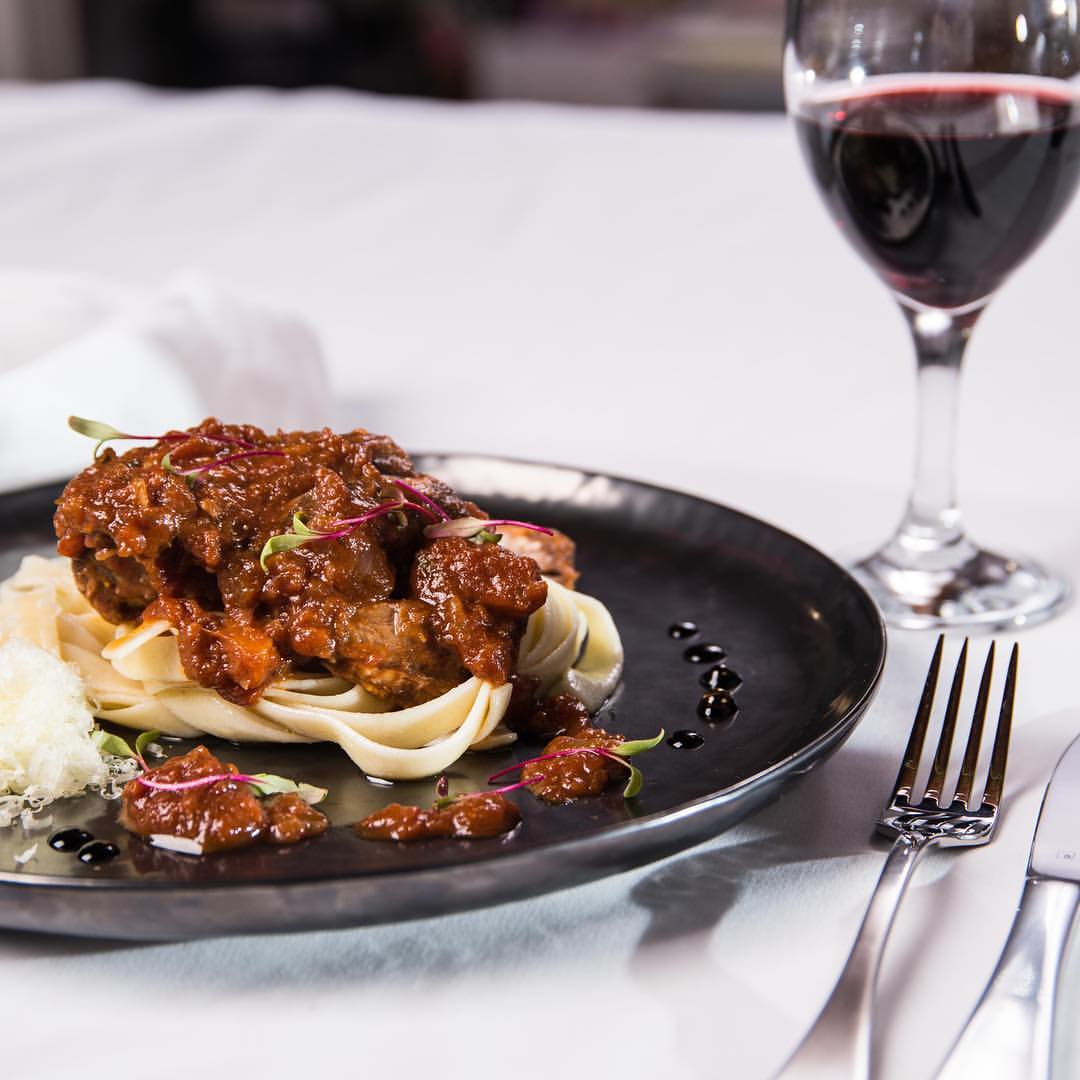 Peter Ansell's slow cooked lamb in a luxury tomato and red wine reduction served on pasta with a glass of red wine