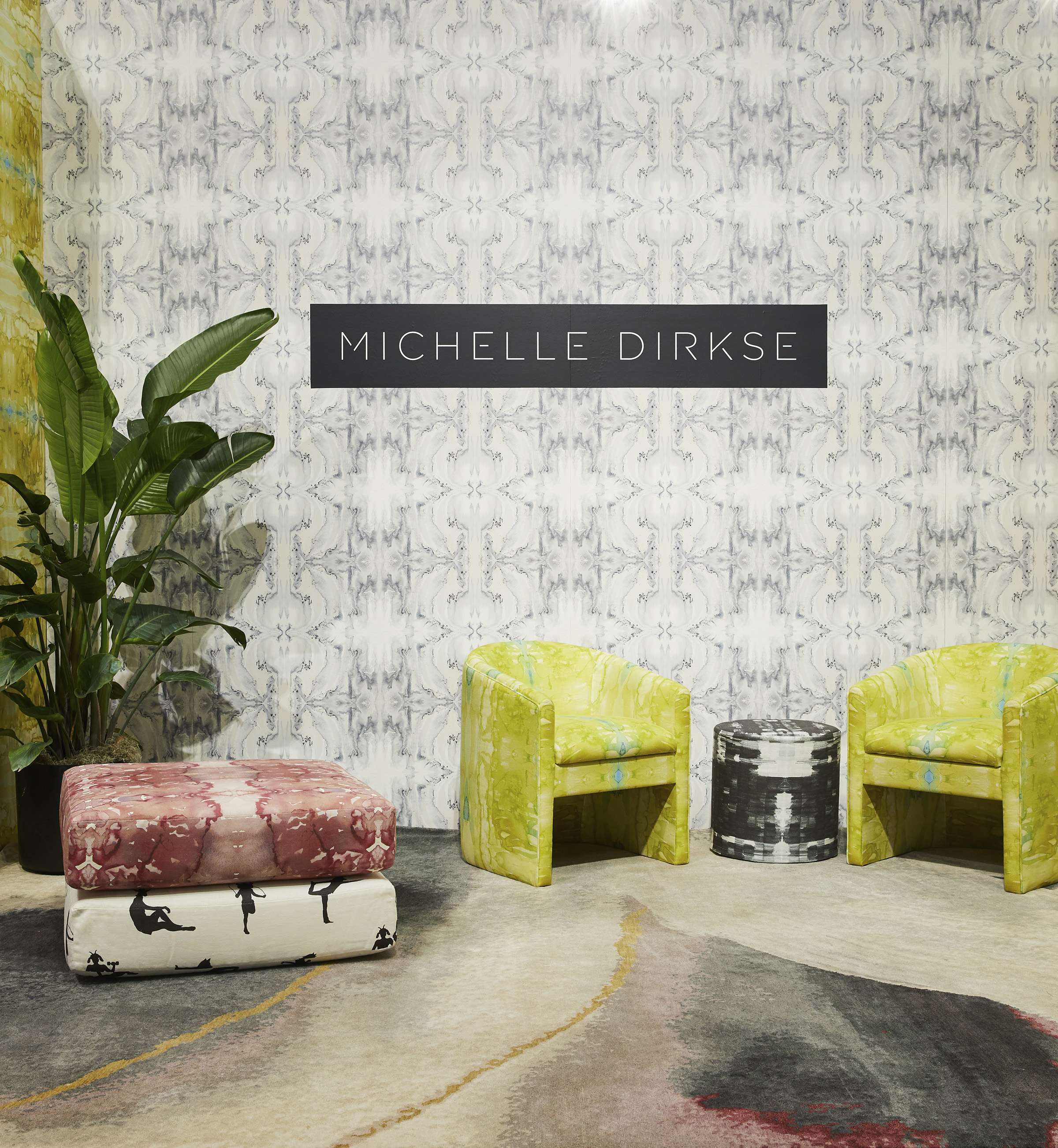 image of repeating Essence wallpaper with two chairs upholstered in yellow Cenote fabric and round ottoman in Sketches fabric, and cushions in Animal Gym and Seaweed fabric with a banana plant and patterned rug for interior designers