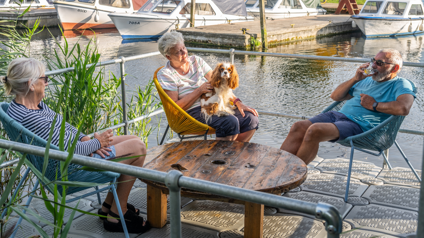 Dog relaxing on Coot Club pontoon with thier family web .png