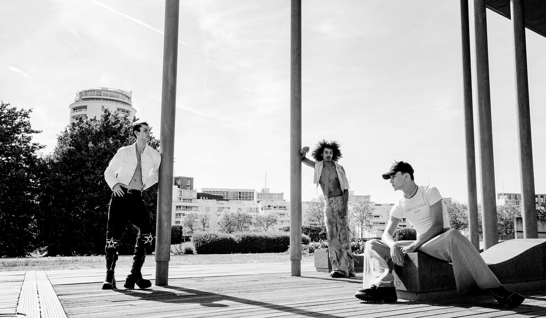 Elegant black-and-white portrait of three models showcasing bold fashion styles, shot by a renowned London fashion photography maestro. This international commercial photographer specializes in editorial spreads, creating impactful imagery for worldw