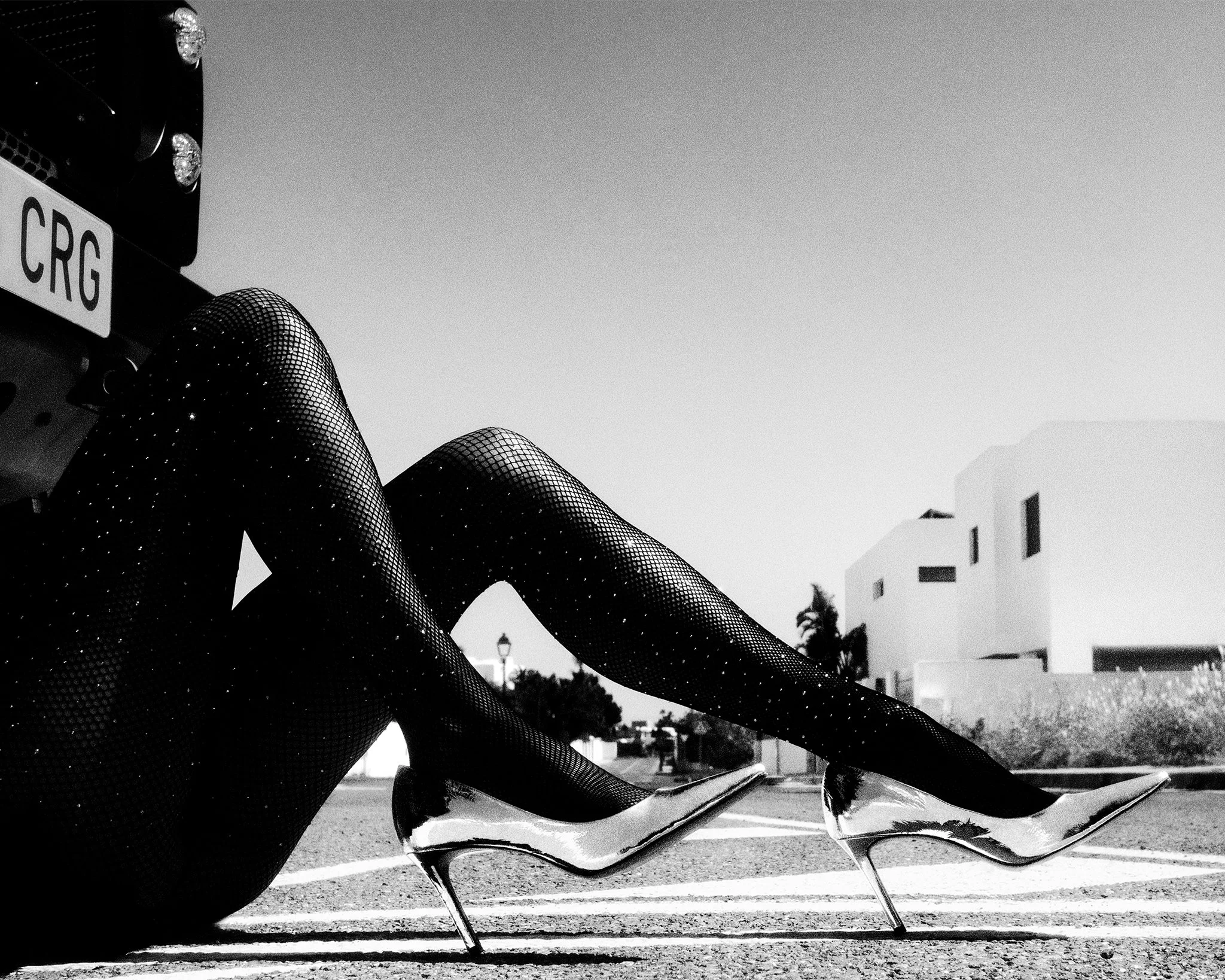 Black-and-white detail shot of a model's legs in sparkling fishnet tights and metallic pointed pumps, from Boris Edrosa's Ibiza Style Magazine editorial