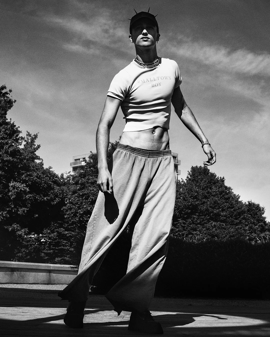Bold black-and-white image of a model in a sleeveless shirt and patterned cargo pants, shot by a celebrated London fashion photography specialist. This worldwide-renowned commercial photographer delivers captivating editorial content, perfect for glo
