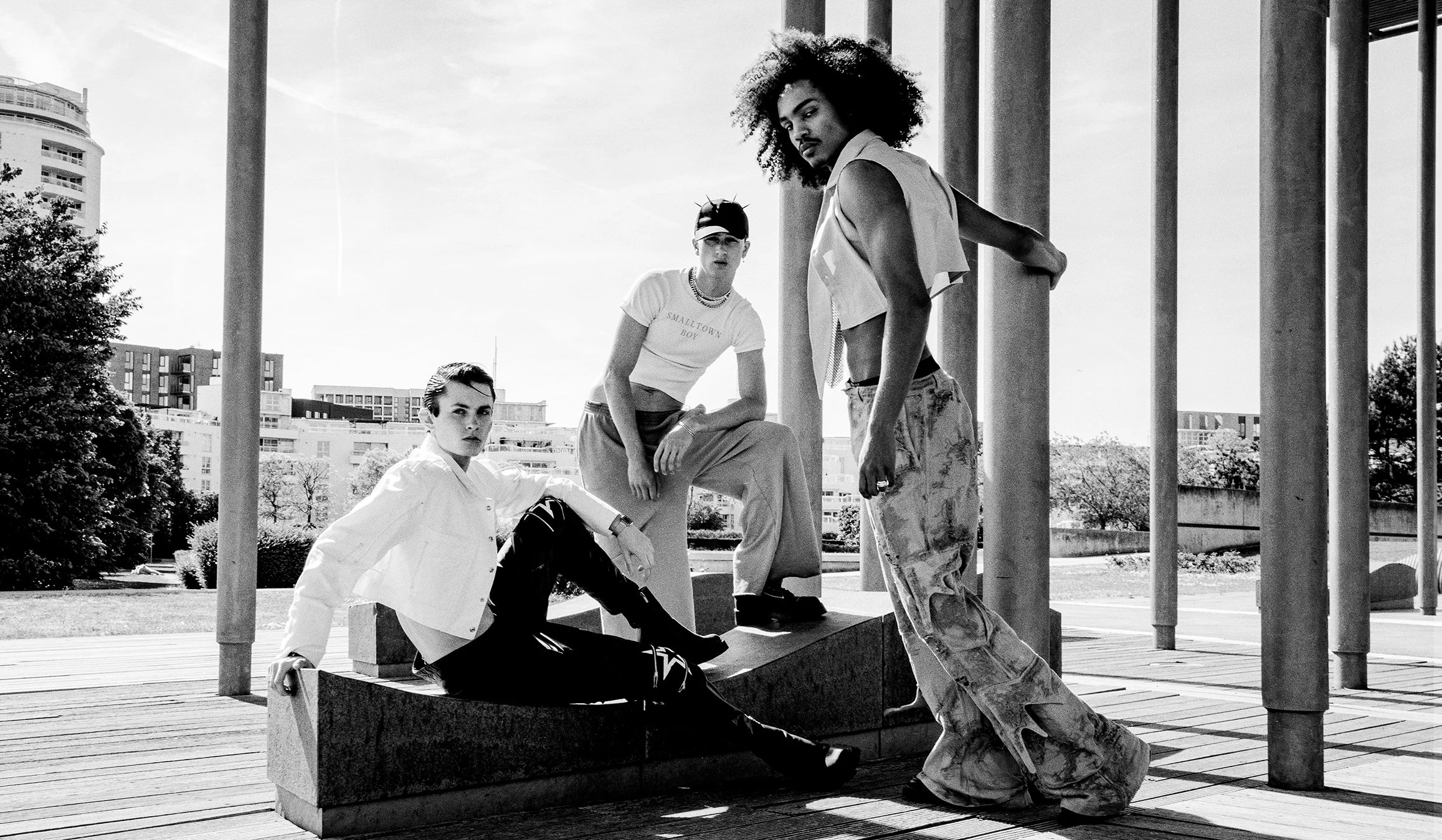 Captivating monochrome image featuring three models in unique outfits, photographed by an acclaimed London-based fashion imaging expert. Known for worldwide editorial shoots and commercial photography, this artist delivers striking visuals perfect fo