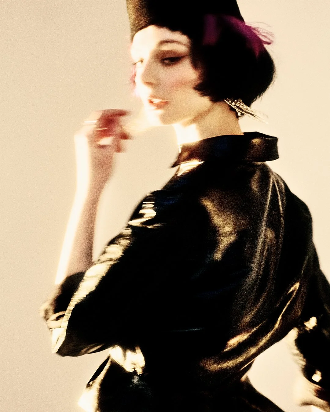 Joyful color fashion portrait of a model with vibrant pink hair and black top hat, smiling brightly in a glossy black leather shirt during an exclusive editorial for PAP Magazine. Captured by a renowned London fashion photographer, this international