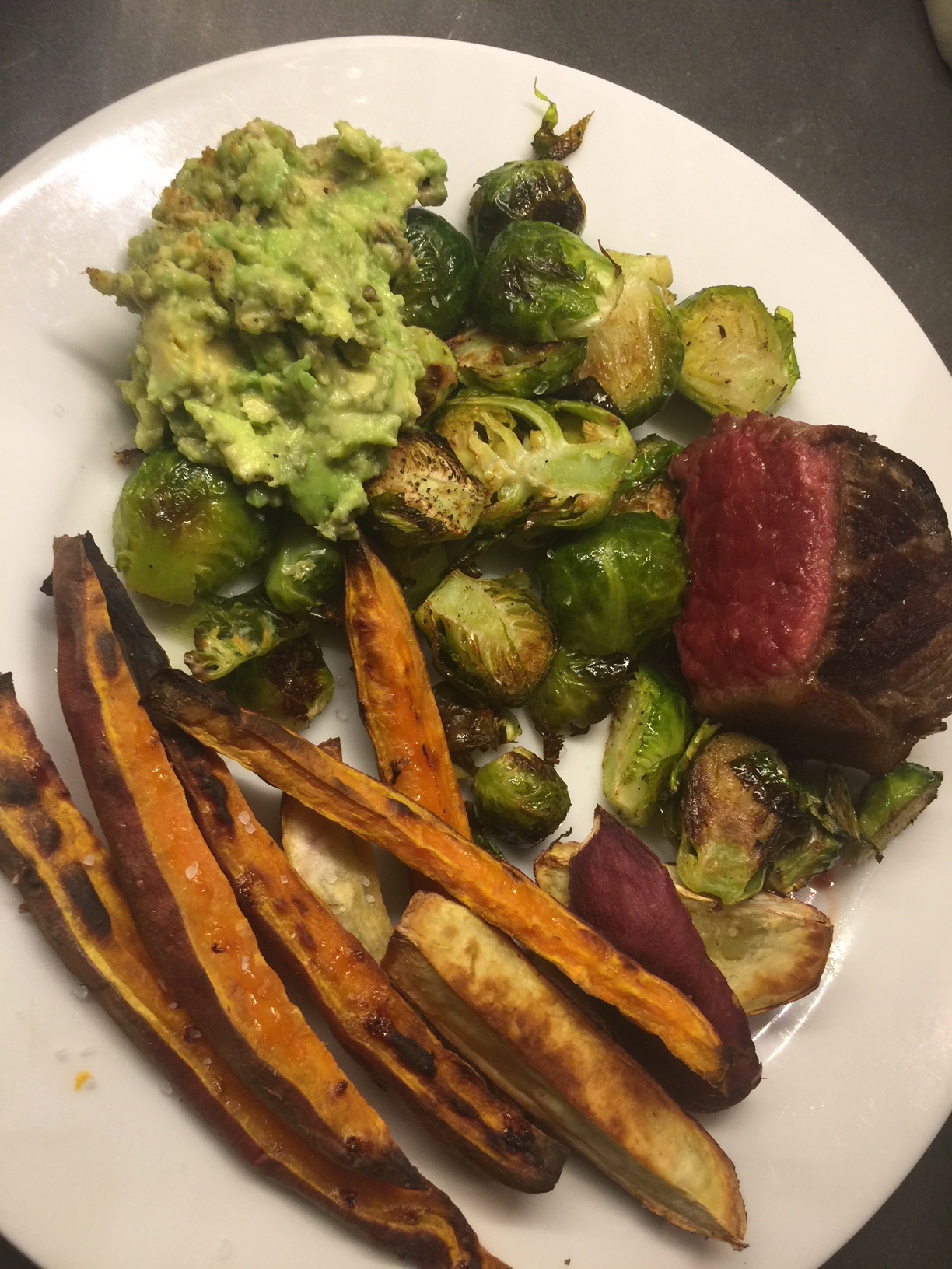 A combo of OG and Japanese sweet potato fries, with brussels, avocado, and grass-fed beef
