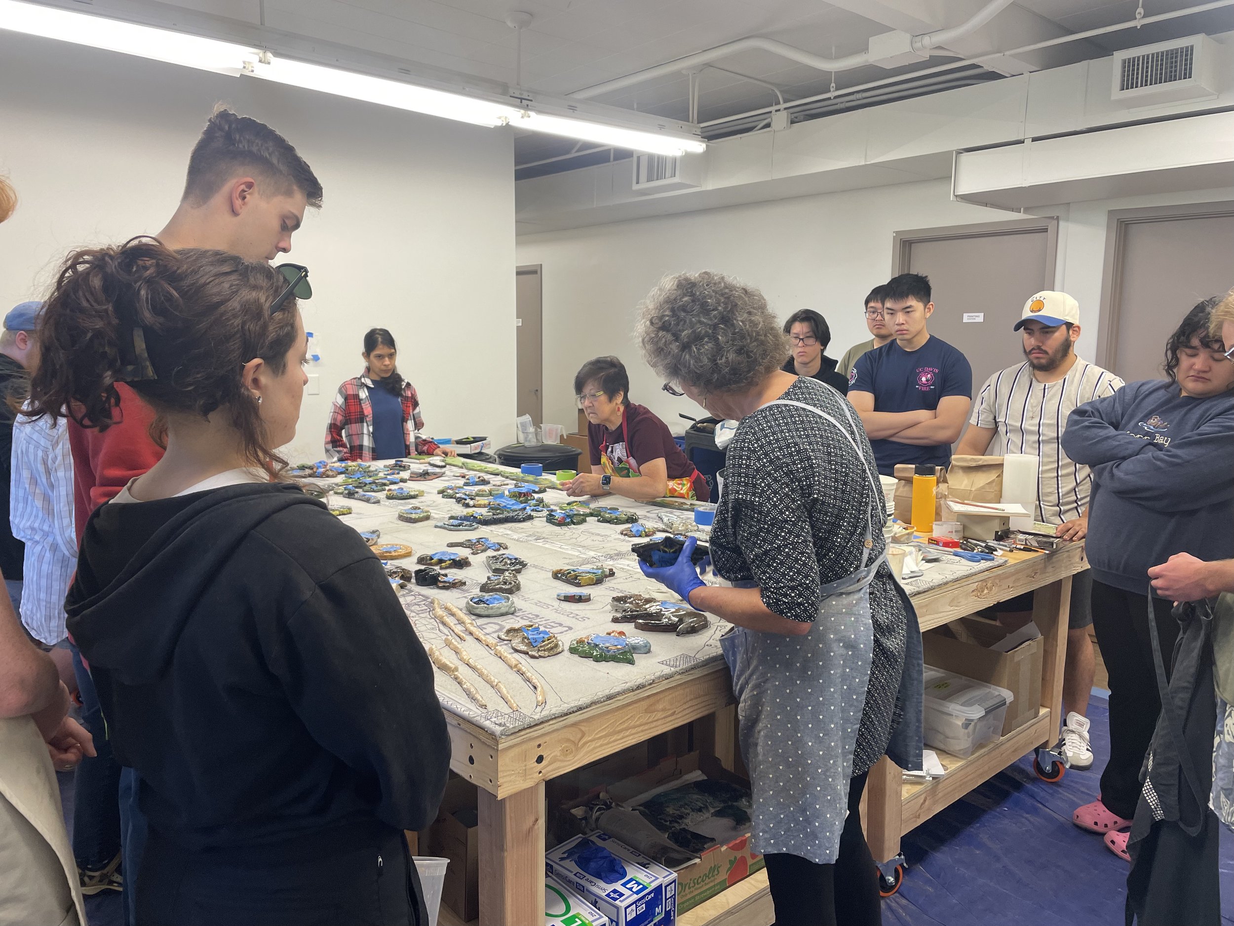 Students learning about how to install their pieces on mural