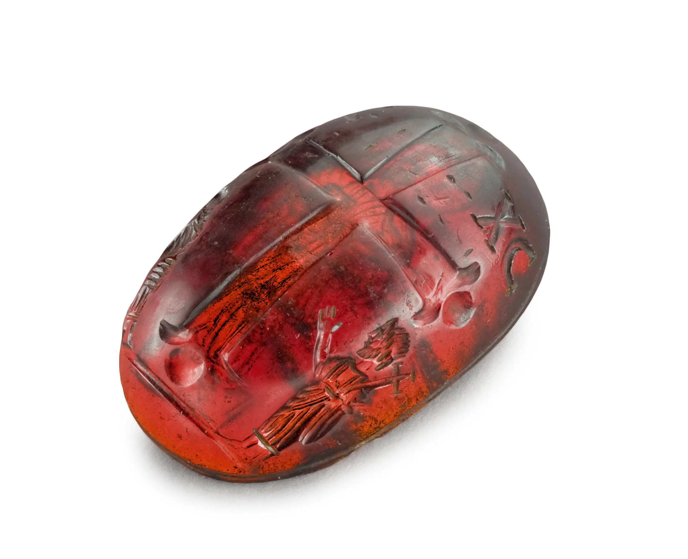 This garnet, sculpted in the shape of a shallow convex dish, is extraordinary both by its size and the purity of the stone. It is carefully and finely engraved on both sides. A large cross with long arms covers most of the exterior surface. The extremities of the Cross’ arms worked as two commas circling a large pearl. The letters IC XC ( Iesos Chrestos ) are engraved on either side of the Cross. The standing figures of Saint Peter and Saint Paul, draped in a mantle, are acclaiming on either side of the Cross. Peter carries a long shafted cross, whilst Paul is recognizable ichnographically: an ascetic man, with a long beard and a bold skull. The interior of the vessel is occupied by a figure of Christ, standing on a scabellum (a small stool) drawn in perspective, and holding a book in his left hand. He wears a long tunic and a draped mantle on his shoulders. The right arm is covered by the mantle, thus preventing the familiar benediction gesture. The Christ is bearded and his long hair falls down upon his neck. A cross shaped halo surrounds his head. A clever visual effect was devised by the artist with the interior side directed towards the light, and Christ appearing on the cross on the exterior. However, this visual effect is not active in the reverse; indeed, when looking through the interior, the cross is simply not visible behind Christ. Stylistically, this figure of Christ can be assimilated to several other examples in glyptic works from the 9th and 10th century, such as the so-called ‘Anne’ double faced intaglio, at the Cabinet des Médailles , in Paris (Babelon 338). Indeed, the image of Christ is represented in the same way, in the same attitude, but surrounded by Deesis (the Virgin and John the Baptist). Yet, another similar standing figure of Christ is also attested on an amethyst cameo from the Dumbarton Oaks collection (inv. 53.7). Nonetheless, one should not discard an earlier dating for this work of art, notably due to the subject matter on the exterior side of the vessel (the acclamation of the Cross by Peter and Paul). It is in fact rare to encounter it in 10th century Byzantine iconography. However, it is featured on a magnificent agate intaglio from the Wavel collection (Krakow, Poland, inv. IX 2607), which dates from the 5th- 7th century A.D. This is one of the finest and best kept intaglios from this period; the bust of Christ tops a large cross surrounded by a Greek inscription which reads: “Emmanuel”. Saint Peter and Saint Paul stand on either side acclaiming the Cross. The usage of such stone in this peculiar shape is also quite unique. A narrow ridge on the exterior rim of the vessel is proof that a second element could have been fitted onto the dish, thus enabling it to close, and creating a hermetically sealed space on the inside. The shape, the iconography of the piece, as well the usage of the garnet all point to a very particular and rare vessel. It is probably a dish that contained the holy-chrism ( myron in the Oriental Church). This holy oil is used to mark the believers during Baptism, Confirmation (Unction in the East) and the ordination of Priests and Bishops. It is composed of pure olive oil, to which balsam (a substance extracted from a tree in Judea and Arabia) is added. CONDITION Entirely preserved; chips on the interior border to the left of Christ. PROVENANCE Formerly, Simkovic collection, collected in the 1970’s. BIBLIOGRAPHY DURAND J. et al., Byzance, l’art byzantin dans les collections publiques françaises , Paris, 1992, n° 184. SPIER J., Late Antique and Early Christian Gems , Wiesbaden, 2007, nos. 575, 576. GRIGG R., The Cross and Bust Image: some tests of a recent explanation , in Byzantinische Zeitschrift 72, 1979.