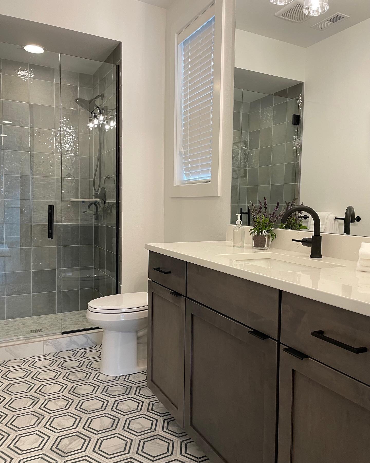 We can&rsquo;t decide what we love better, the patterned floor tile or textured wall tile 😍 How about we just say both! This guest bath is the perfect example of playing with texture and pattern while still creating a timeless look. 
Floor: @daltile