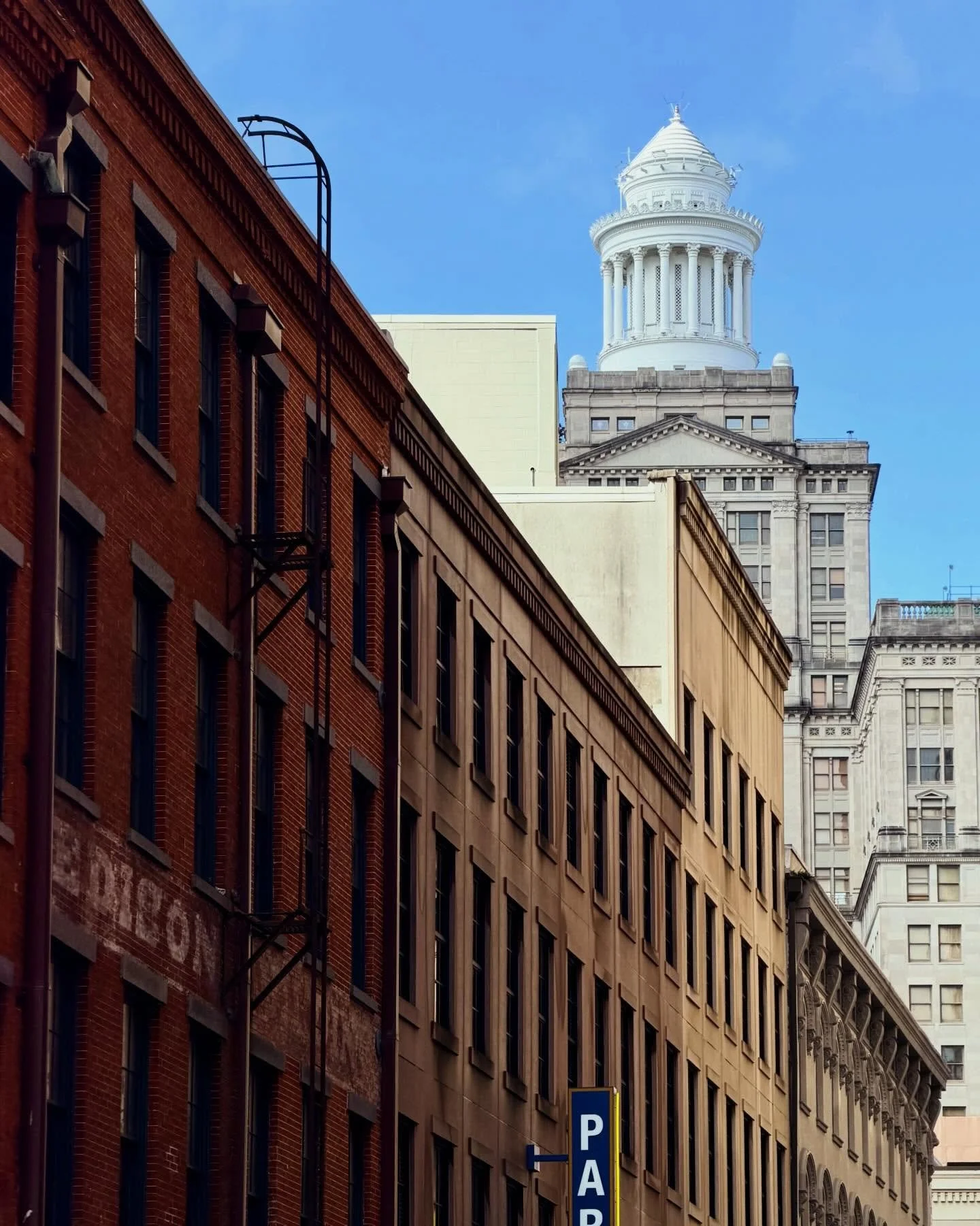 The historic 1920 Hibernia Bank building once dominated the New Orleans skyline. Its fanciful tempietto served as a beacon for ships navigating the Mississippi River and as an indicator of the next day&rsquo;s weather. Natchez Alley in the foreground